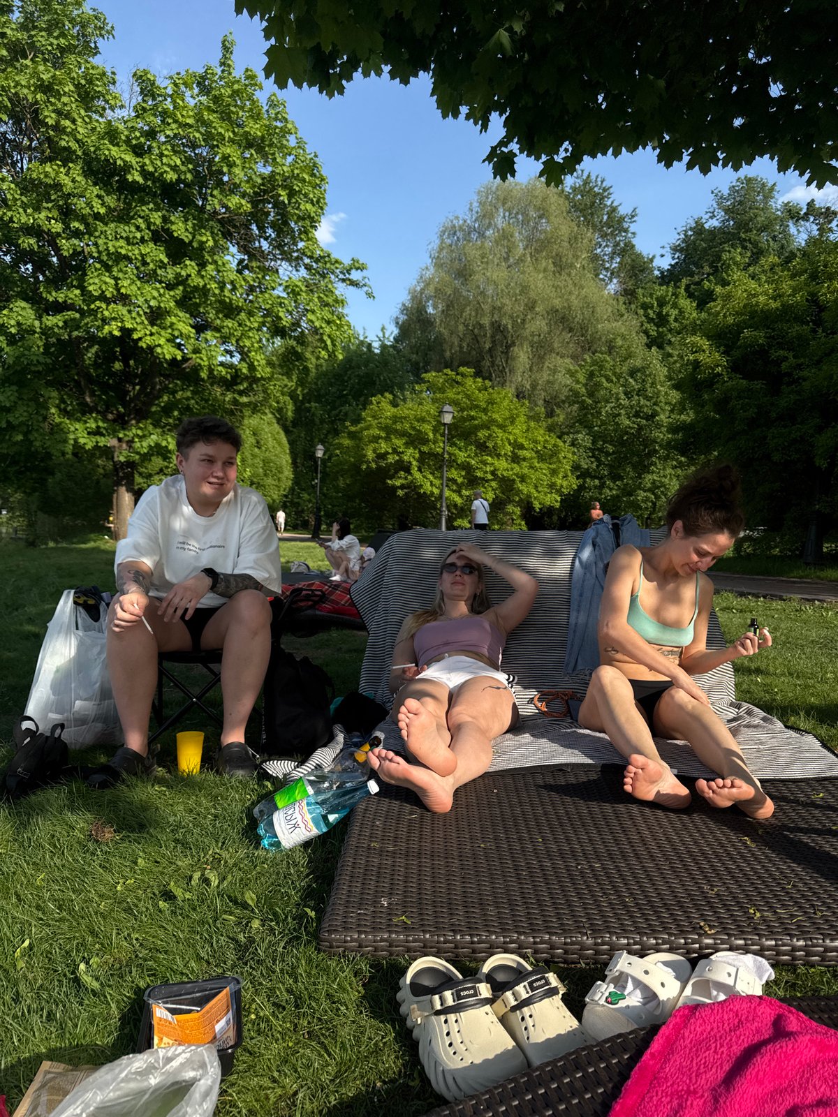 Three People Enjoy Sunny Afternoon in Moscow Park