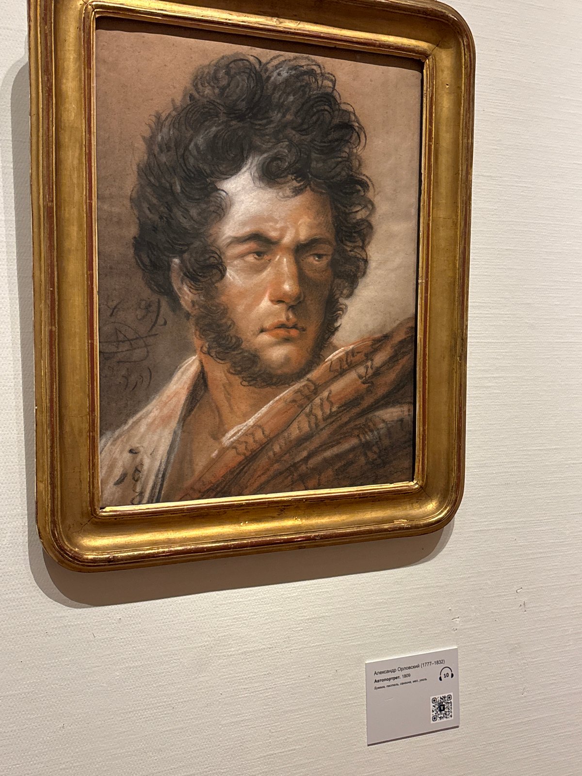 Woman photographs historical portrait collection at Moscow gallery