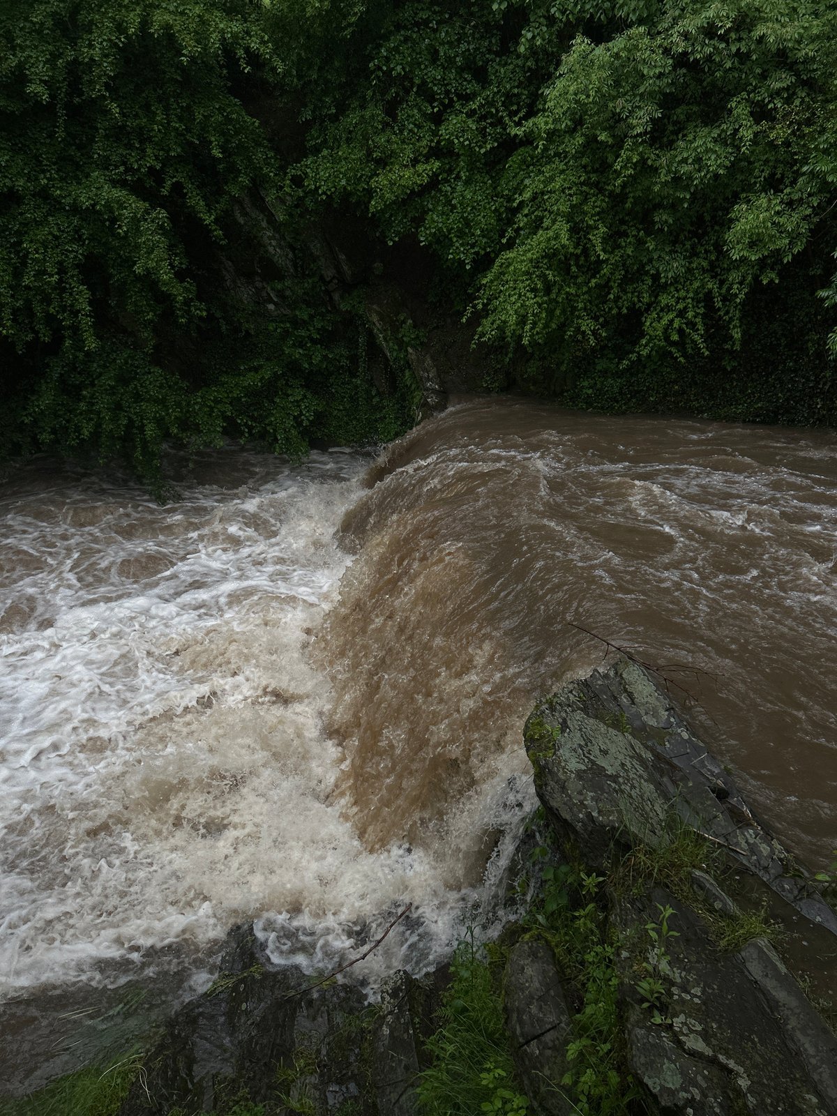 Storm-swollen waterways and flooding documented across unknown location