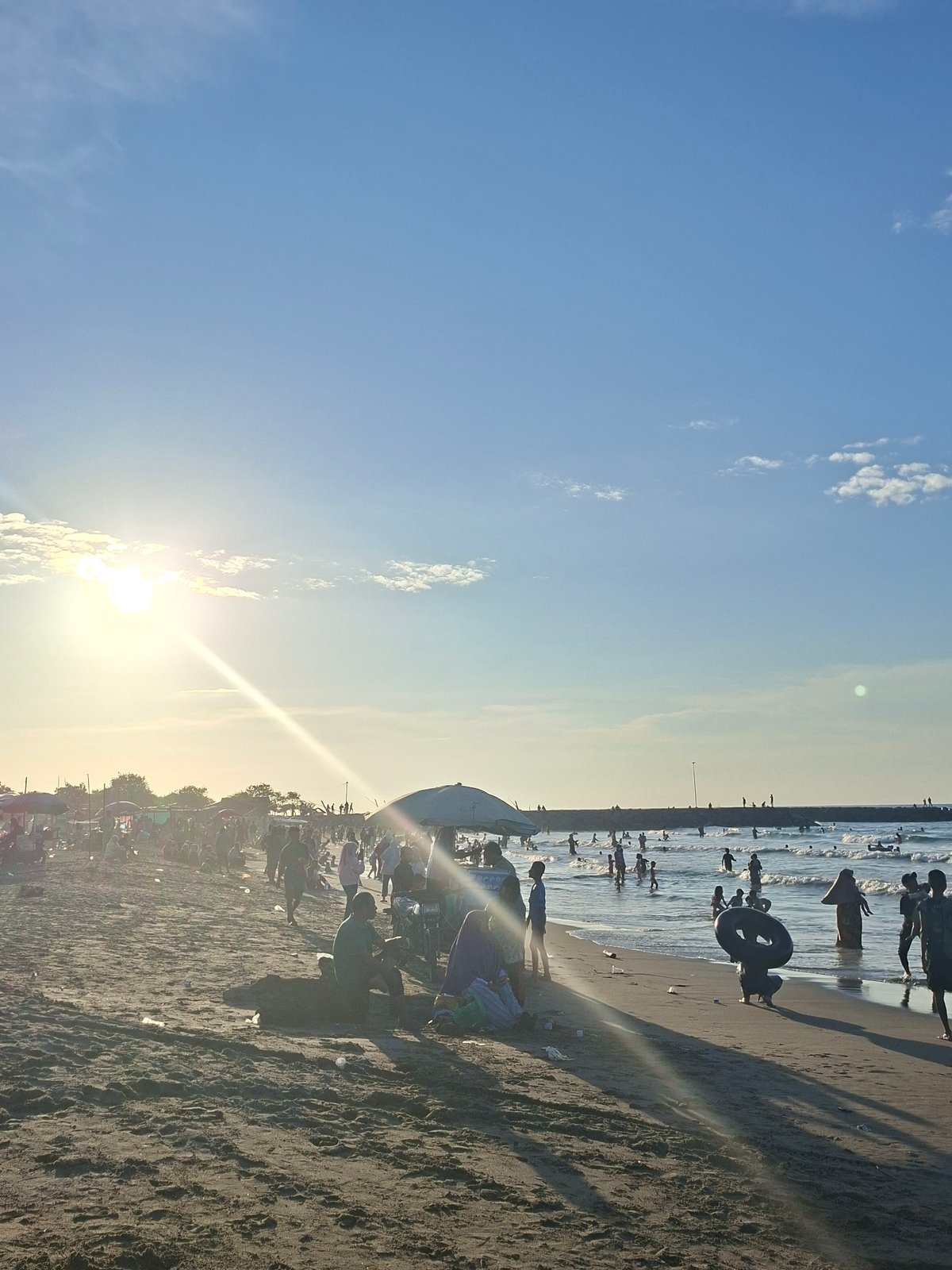 Beach life captured during morning hours in Indonesian coastal town