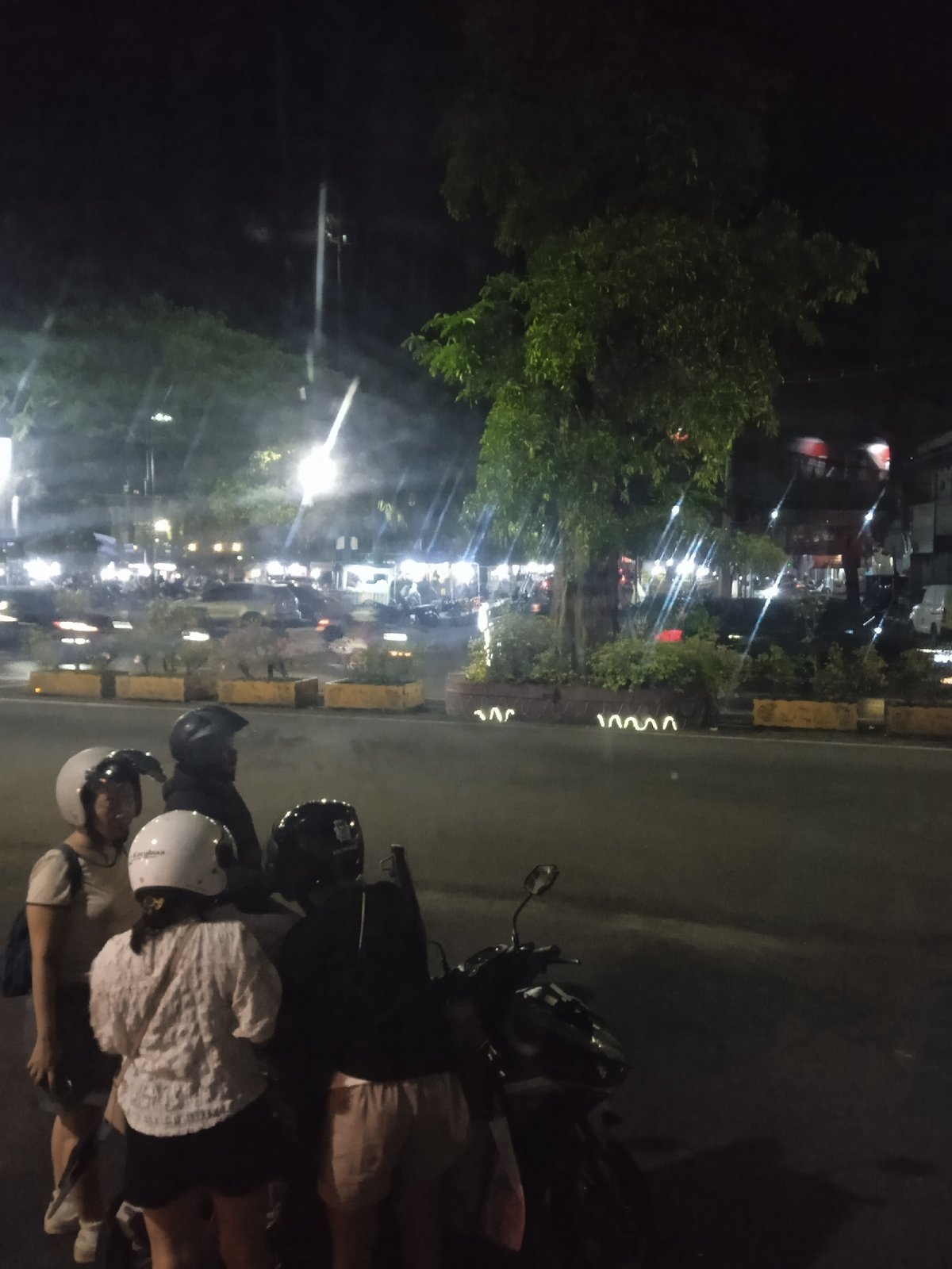 Evening scenes captured in Madiun: motorcyclists and train passengers