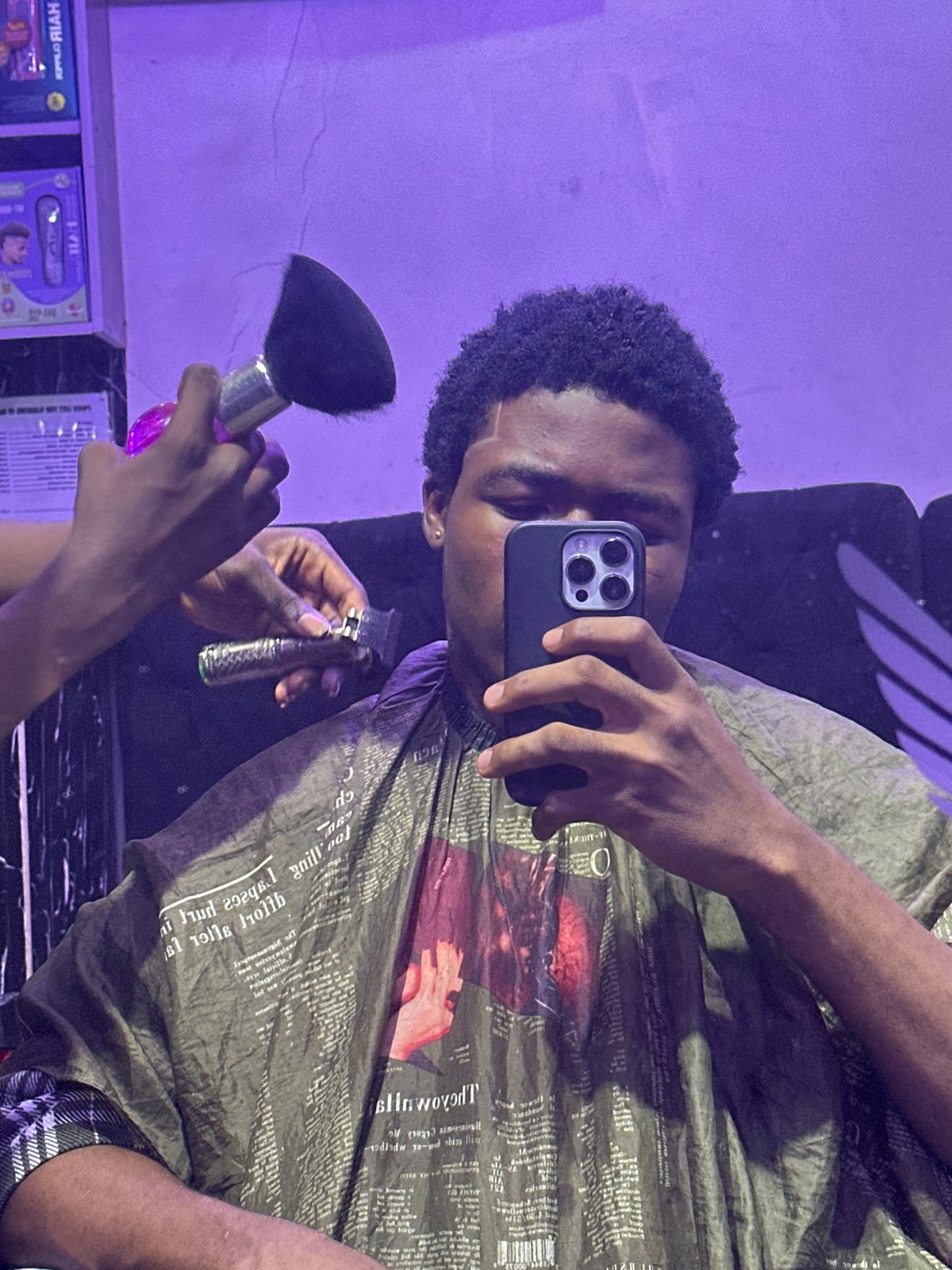 Customer takes selfie during barber shop visit in Nigeria