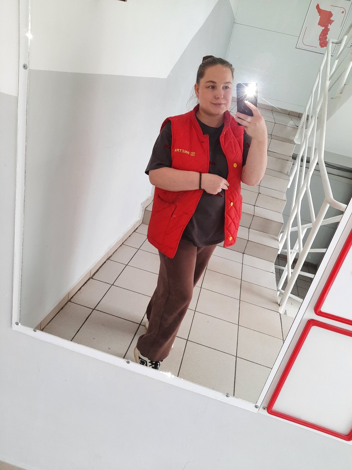 Person takes mirror selfie in Izhevsk building hallway