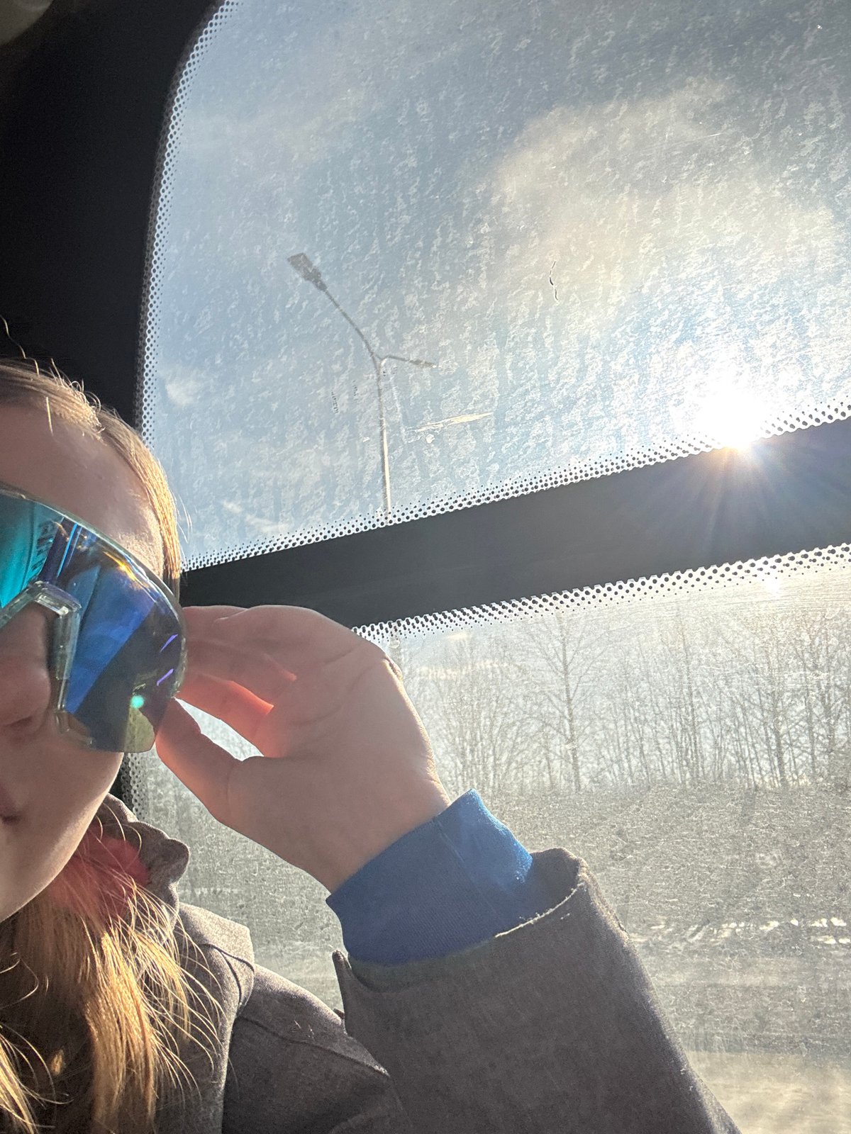 Person adjusts blue sunglasses in vehicle in Berezniki