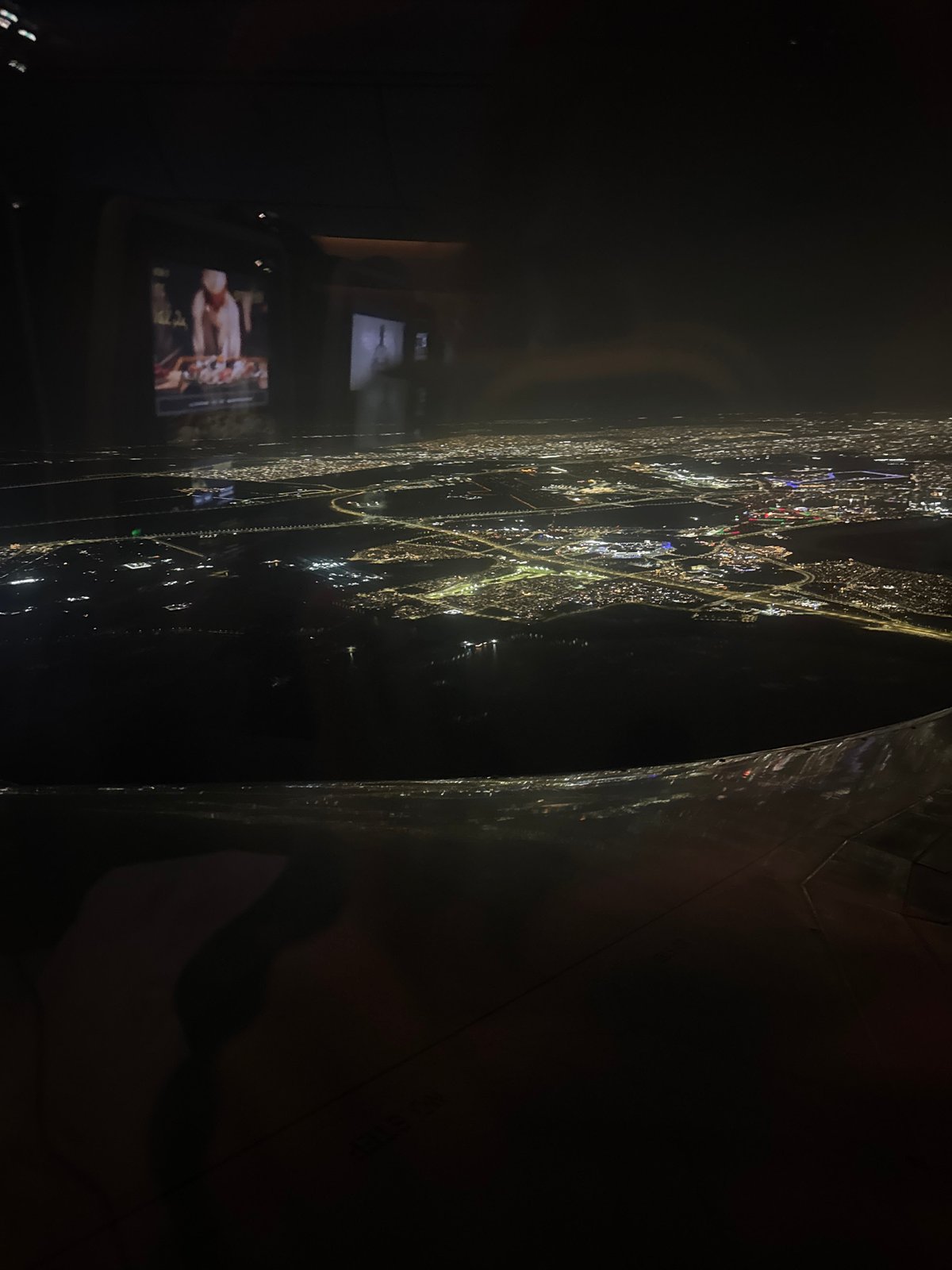 Nighttime Osaka skyline viewed from observation deck through reflective surface