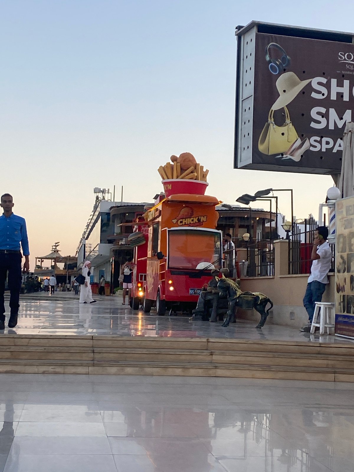 Sharm El Sheikh promenade at dusk: sculptures, stalls, and street life