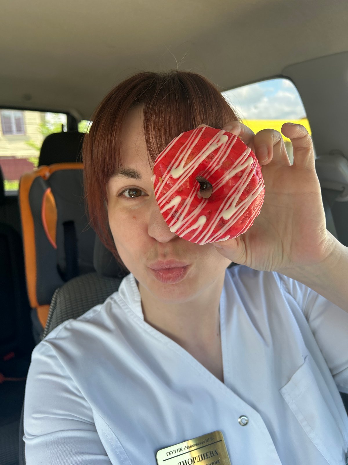 Woman poses playfully with donut, captured outdoors in Russia