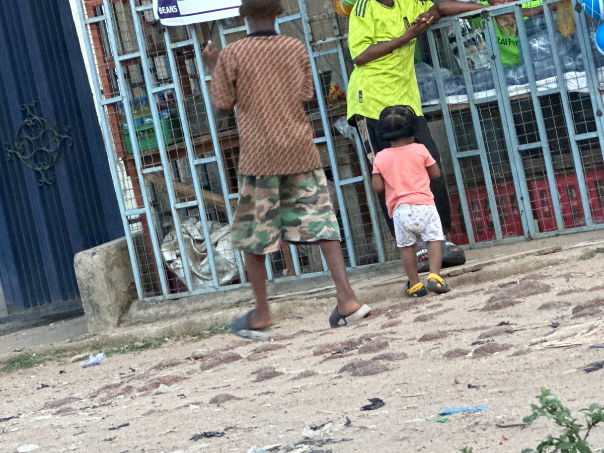 Children gather near metal structure in brief afternoon encounter