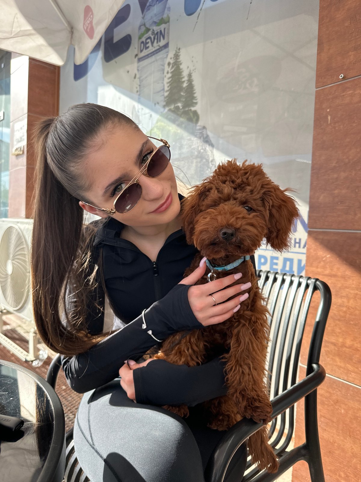 Woman with small dog enjoys afternoon at Plovdiv cafe