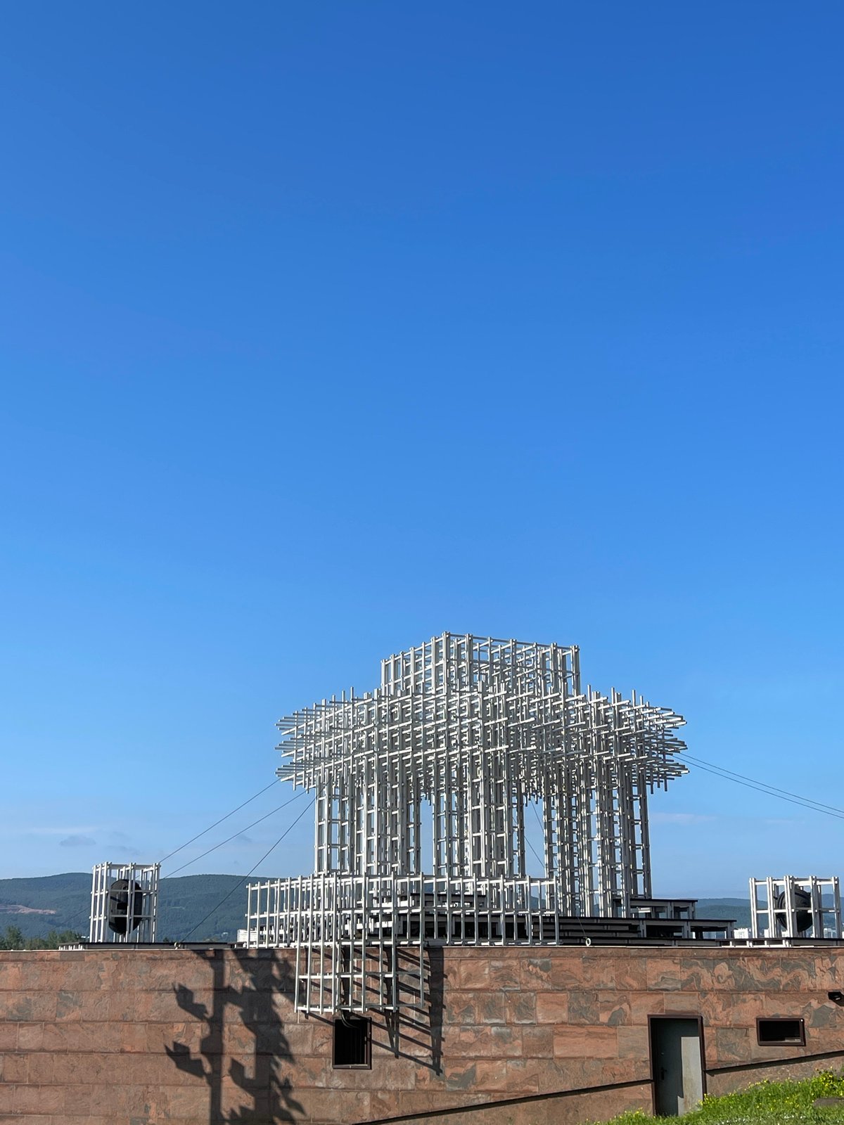 White lattice sculpture and riverfront architecture in Krasnoyarsk