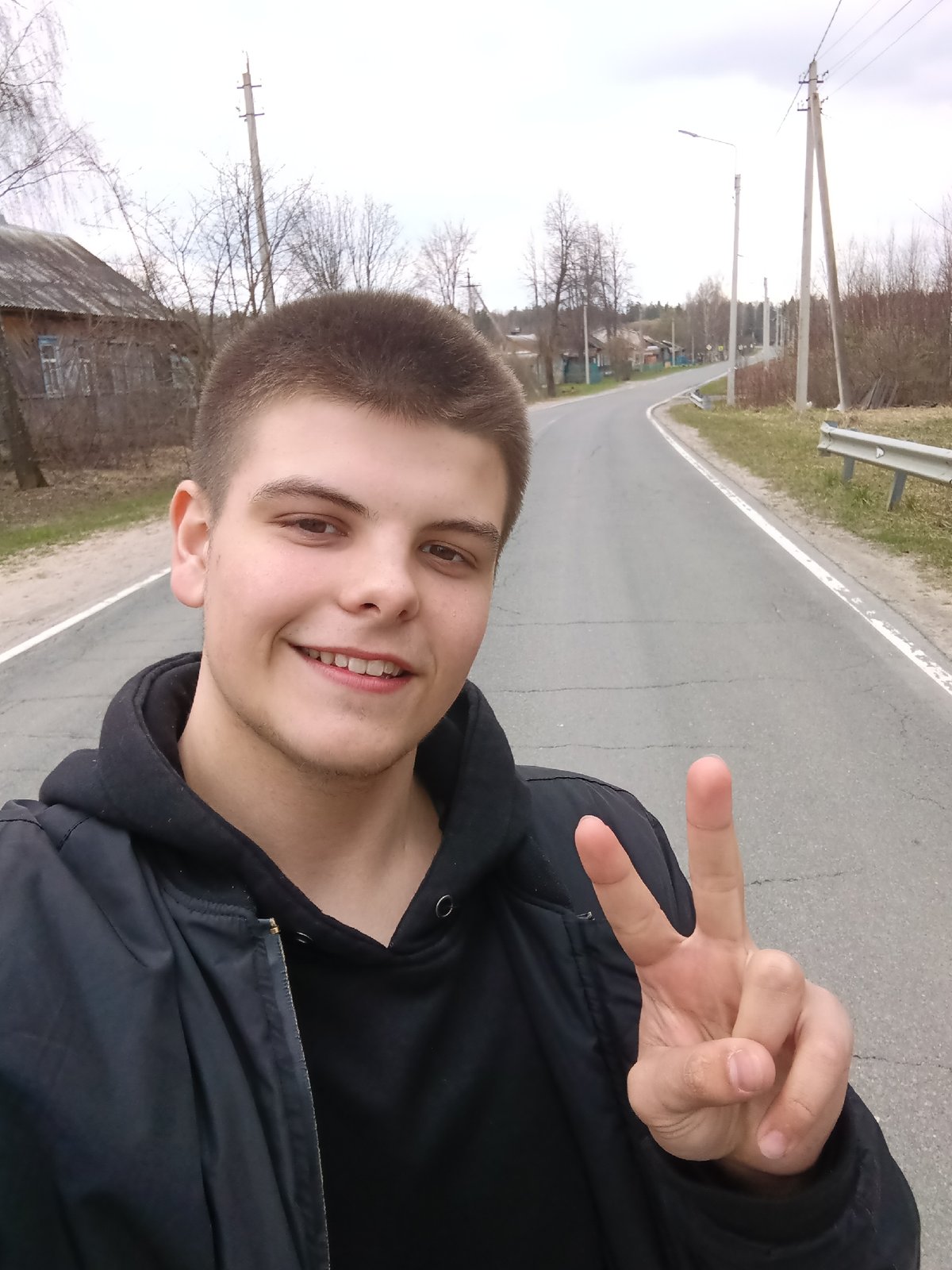 Young man takes selfies on rural road in Russia