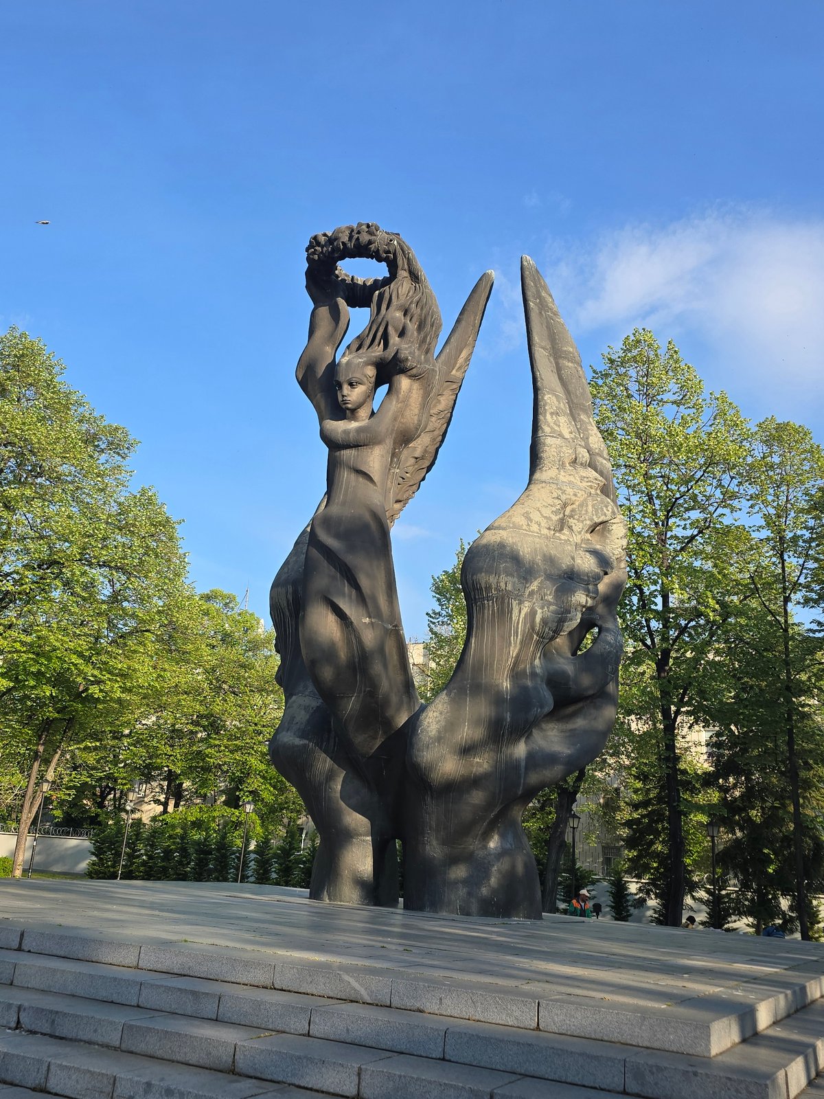 Bronze memorial statue with wreath observed in sunny park