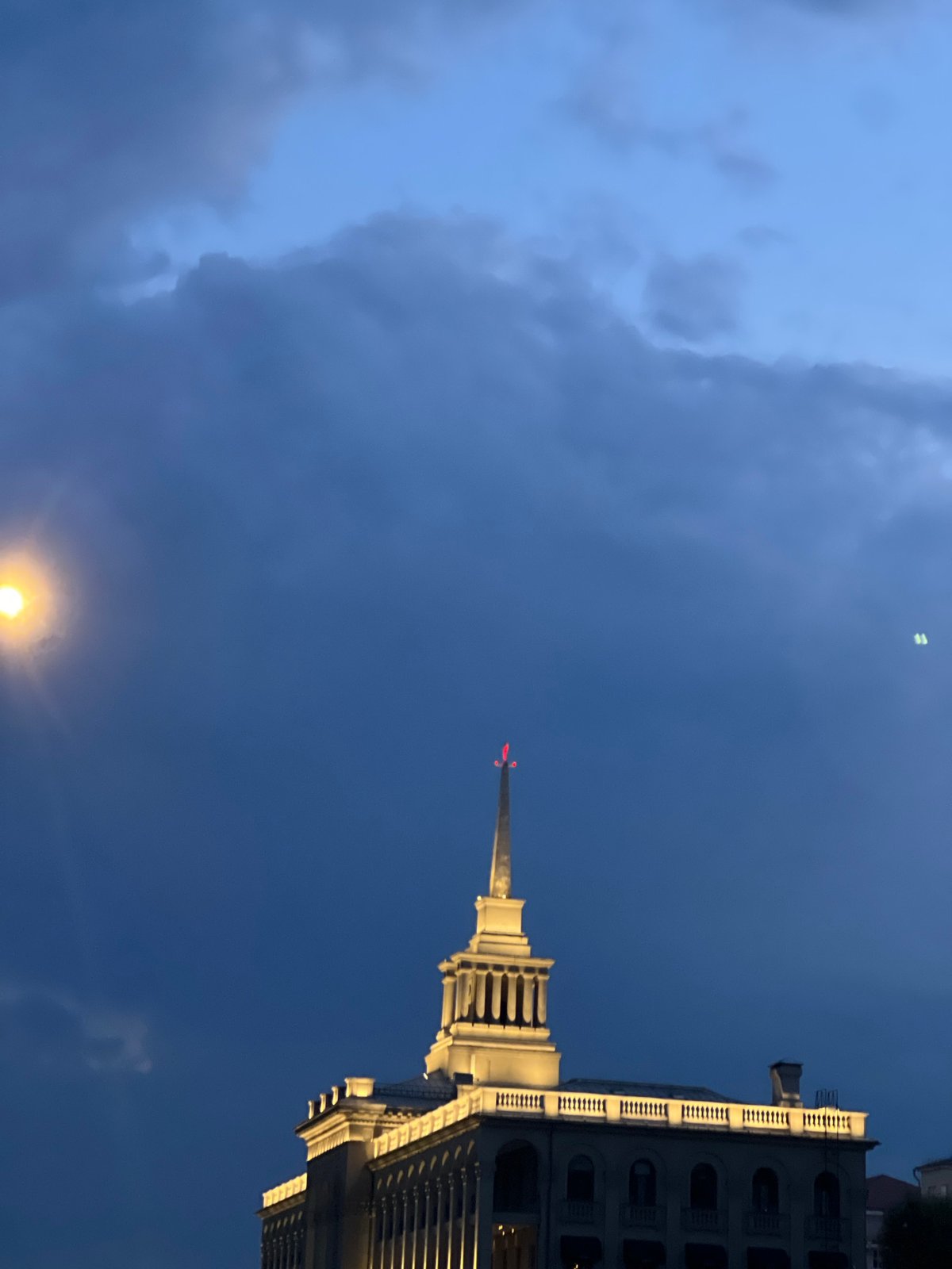 Dark blue evening clouds over Krasnoyarsk with a bright light below