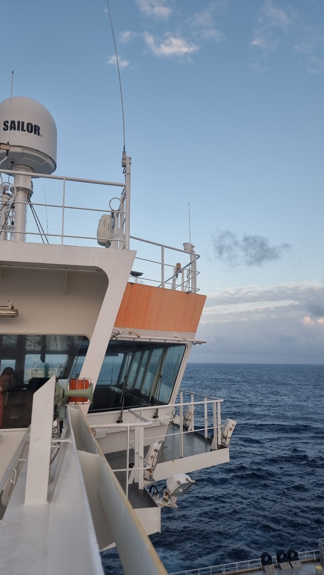 Tanker ship underway on open ocean, deck and bridge in view