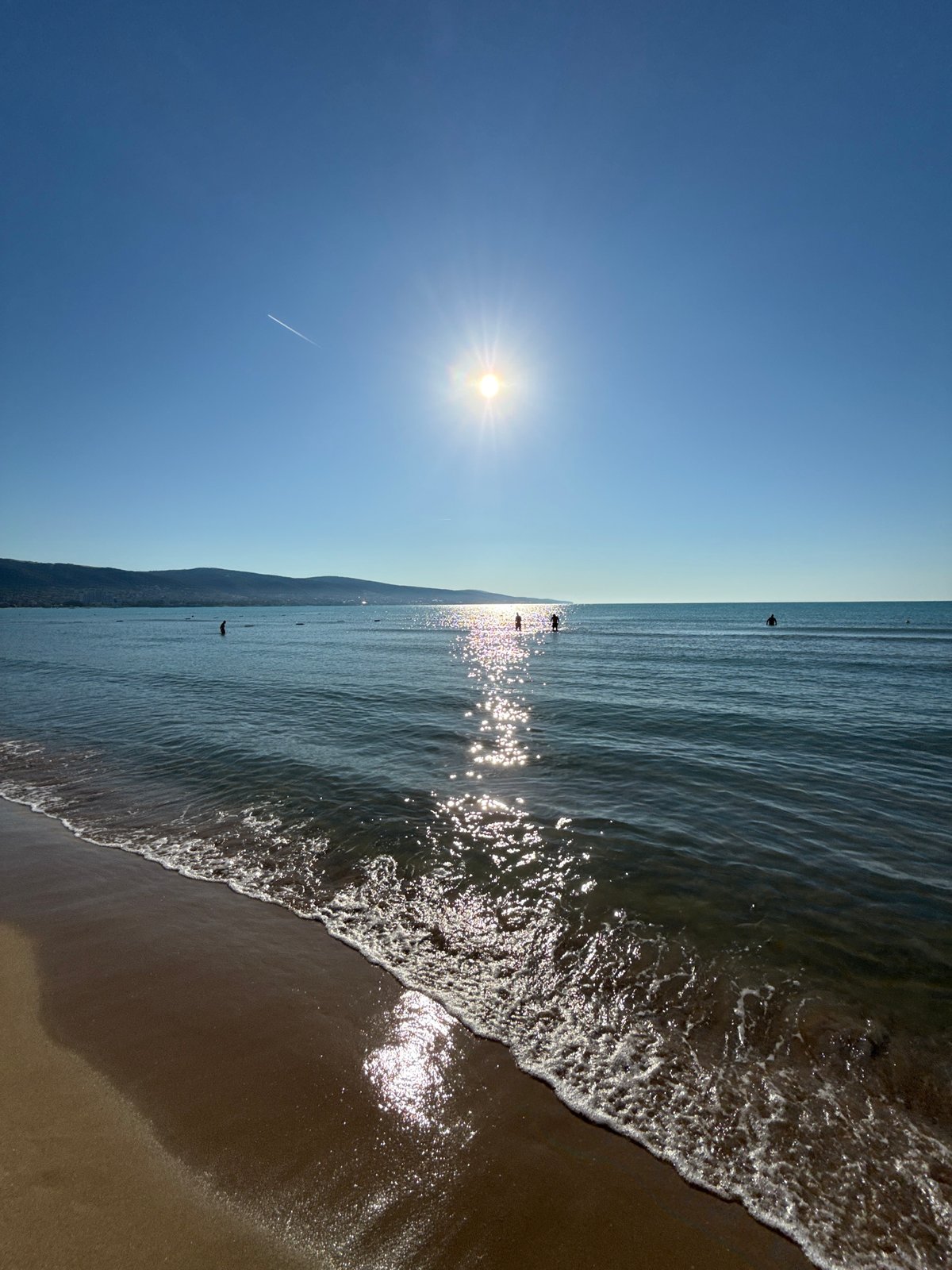Woman takes selfies on sunny Nesebar beach morning