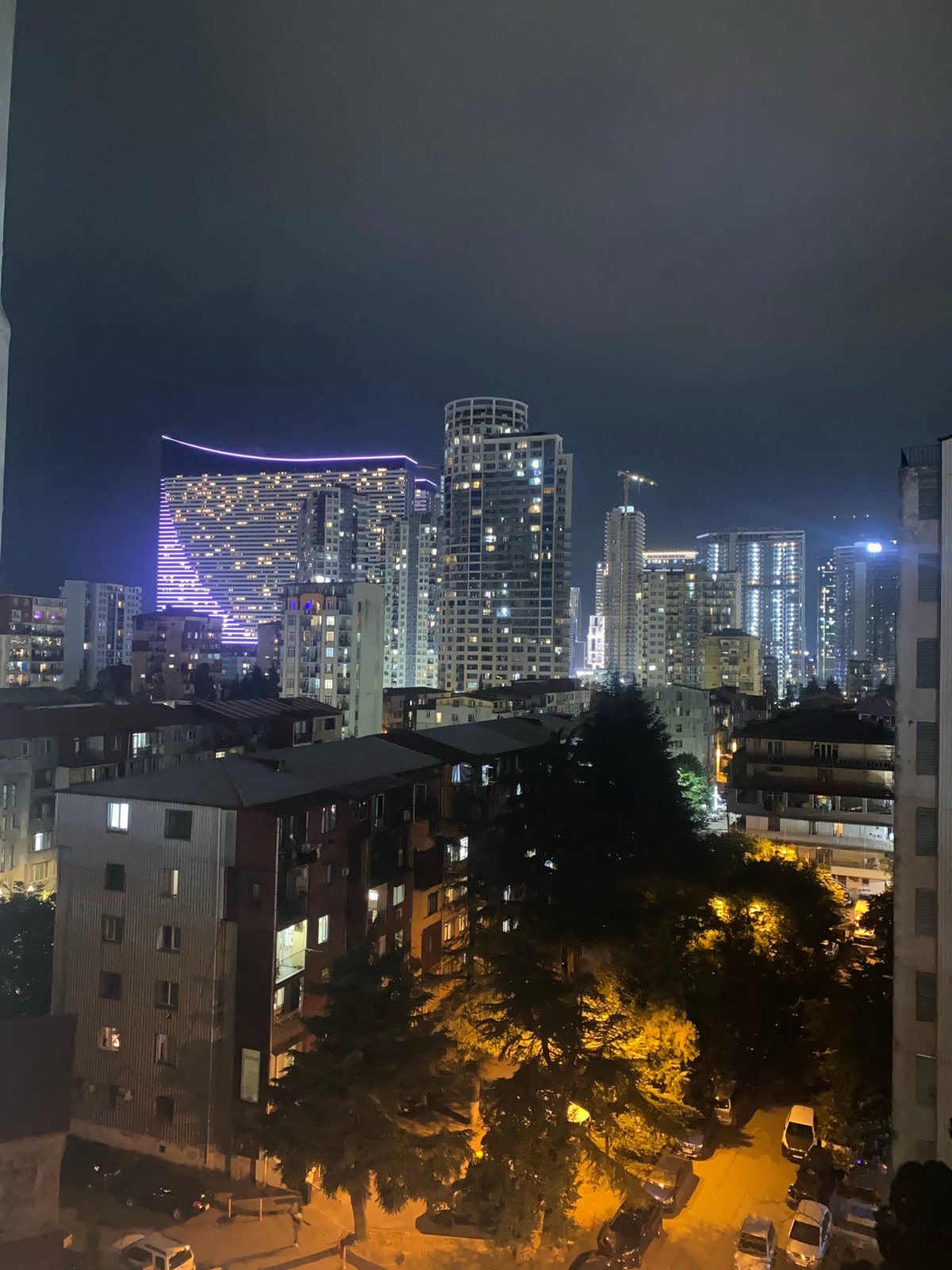City district at night, lit towers and street activity