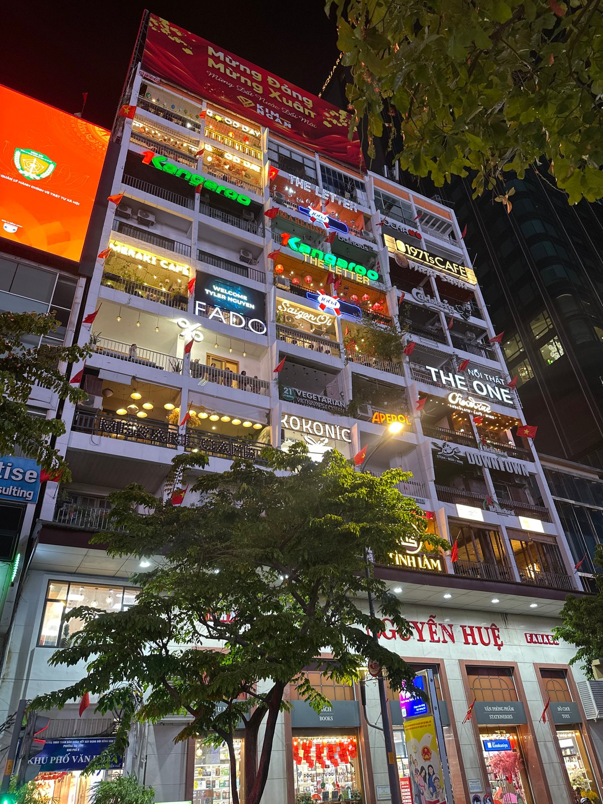 Commercial building with lit business signs observed in Thủ Đức