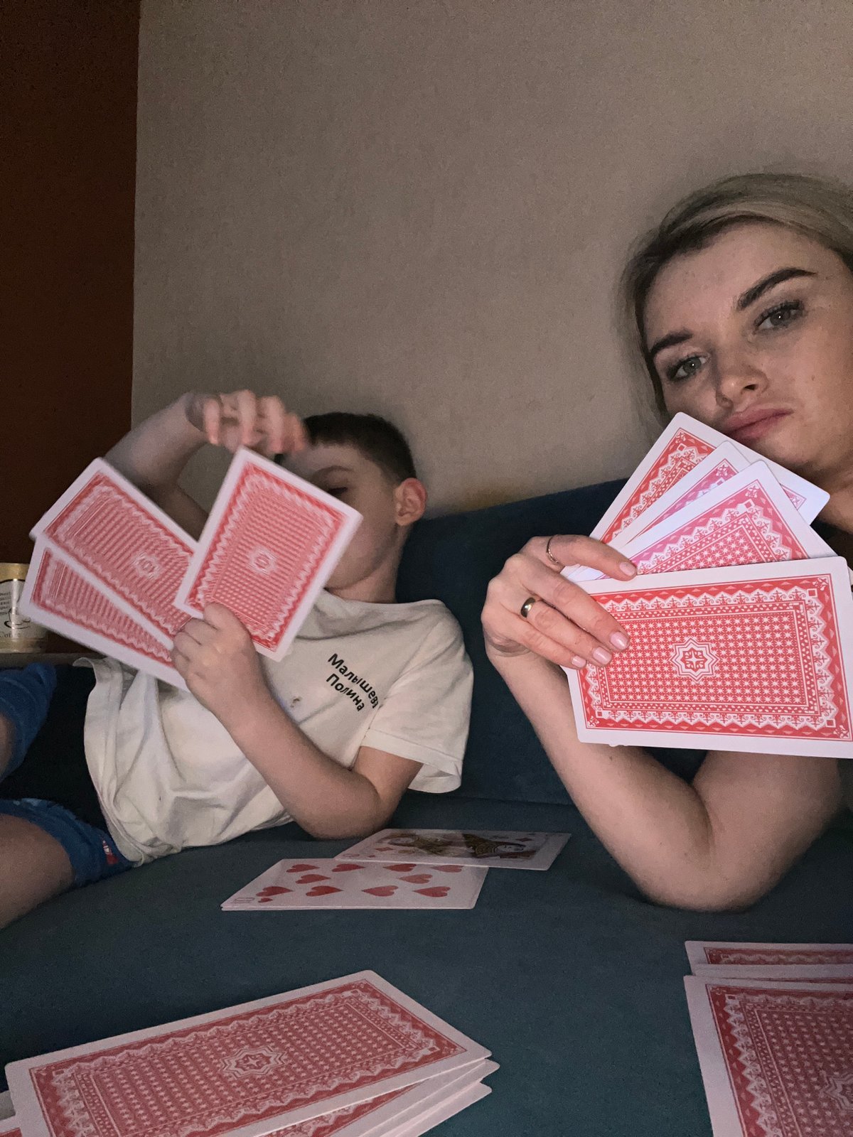 Woman and boy play cards indoors in Chaikovsky, Russia