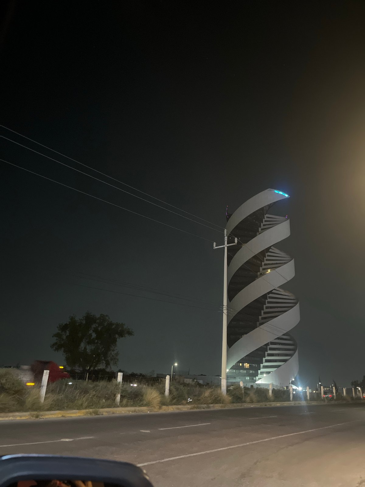 Modern spiral pedestrian bridge documented at night in Tlaxcalancingo