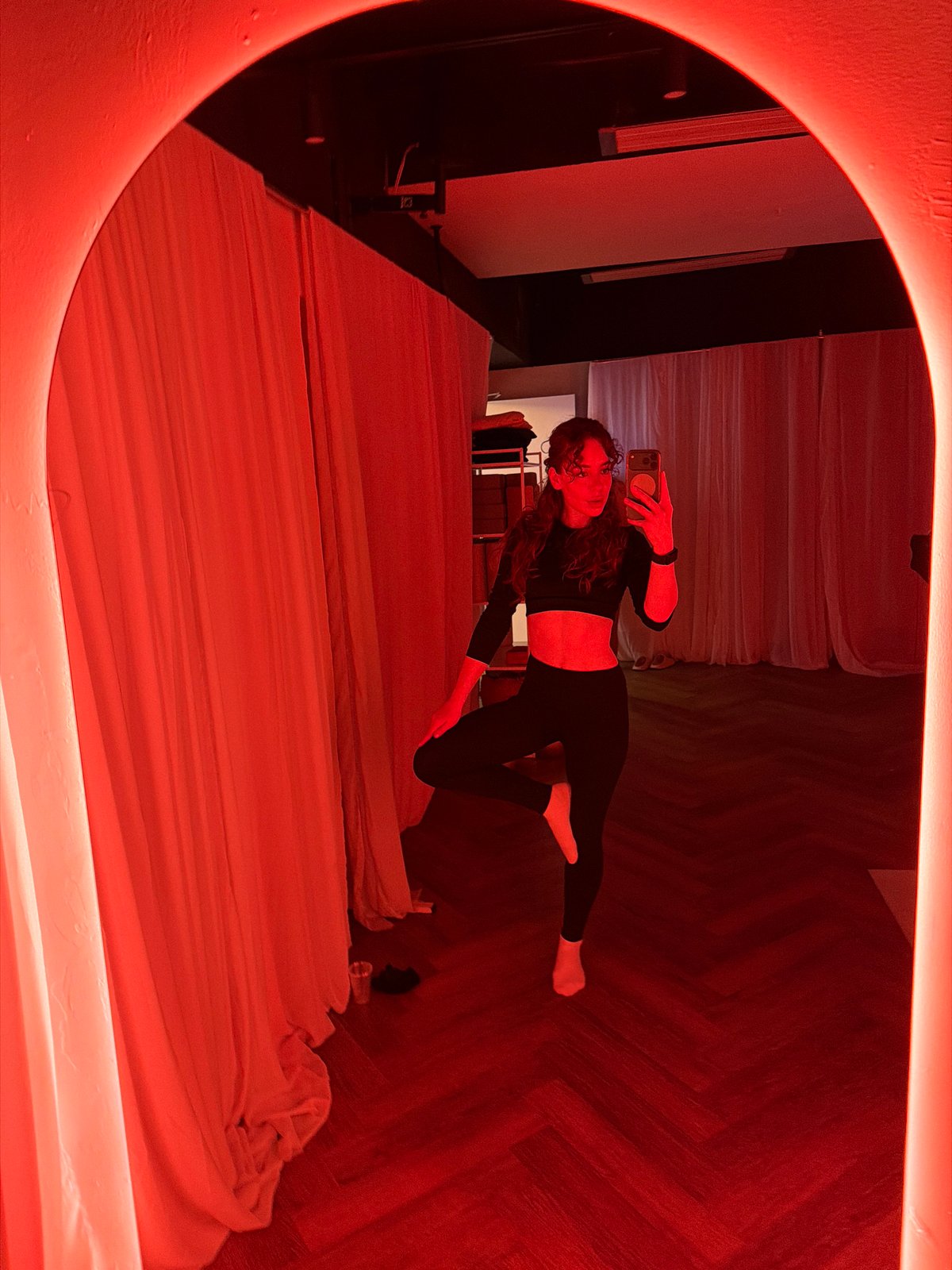 Woman takes selfie in red-lit room in Moscow