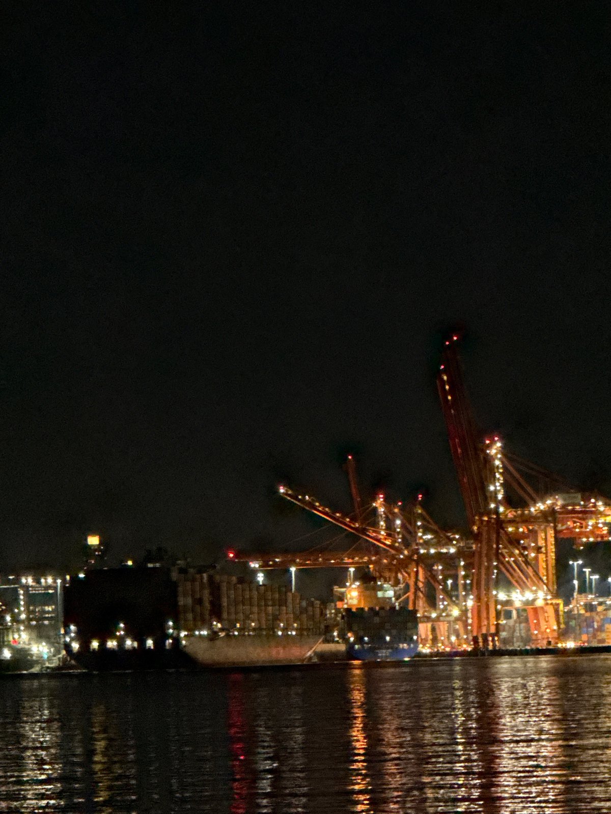 Container ship docked at Vancouver port during nighttime operations