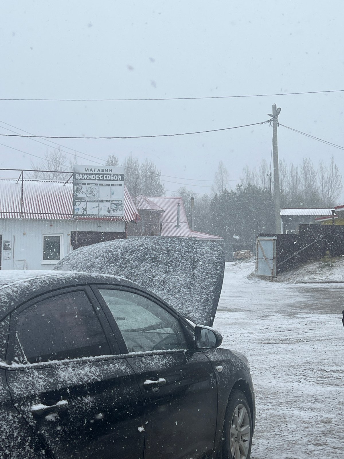 Snow-covered car parked on winter street in Kliuchi, Russia