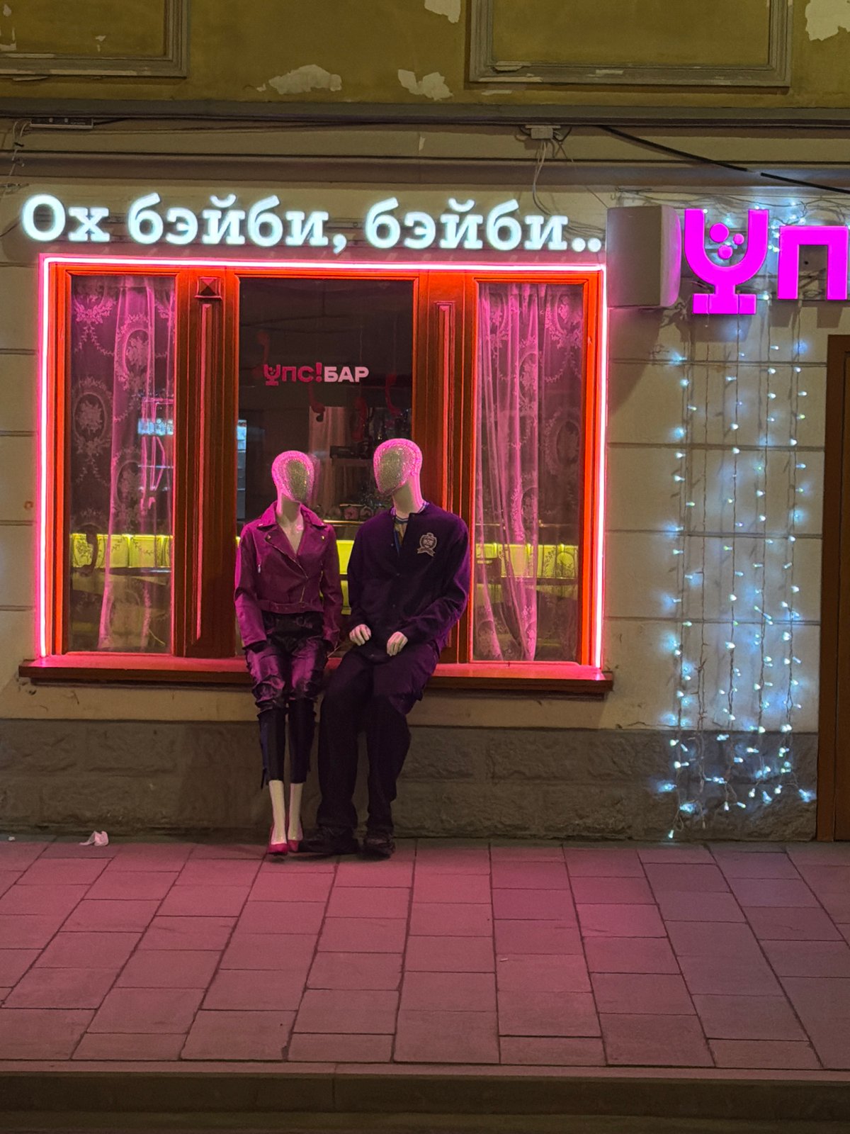 Moscow bar exterior with neon signage, mannequin display observed