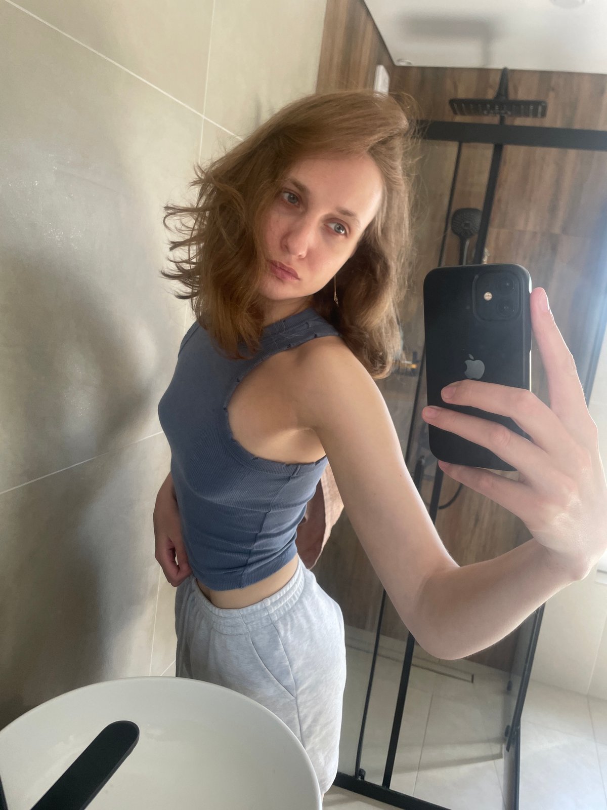 Woman takes morning selfies in Russian bathroom, holds perfume