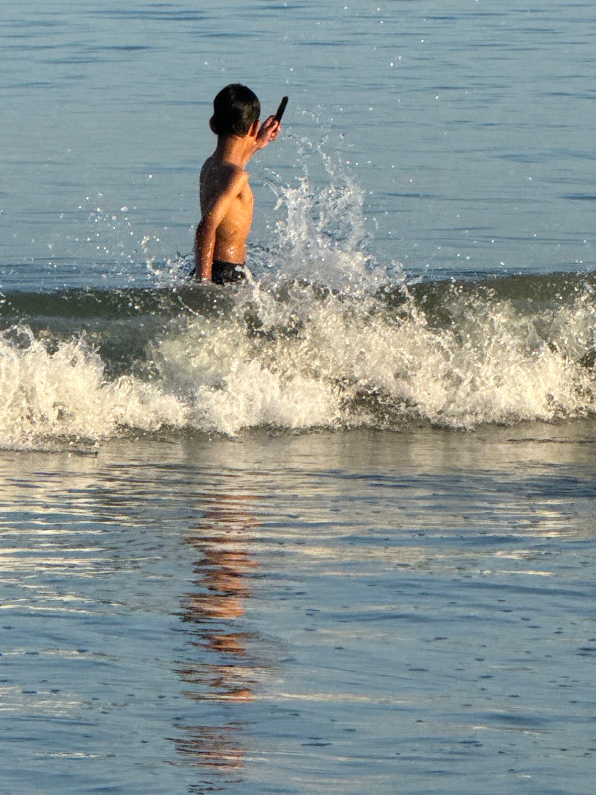 Evening beach play: families enjoy surf at Indonesian beaches
