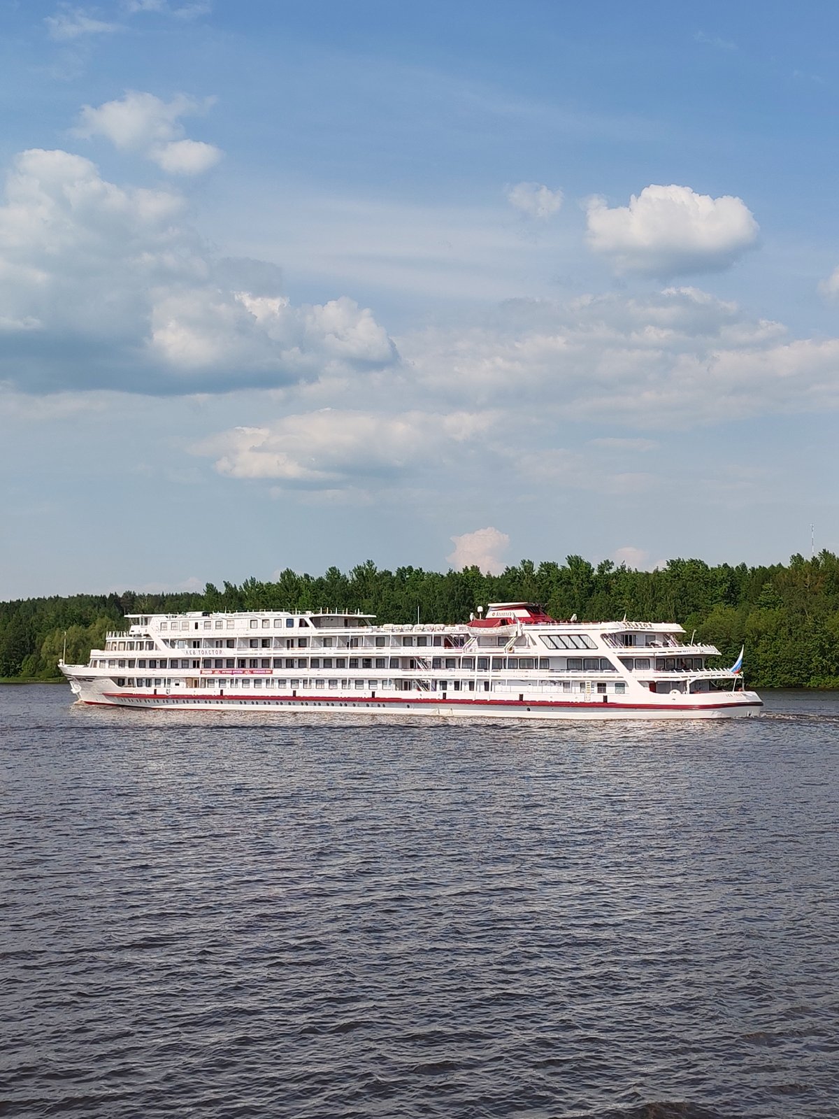 Passenger ship Lev Tolstoy cruises Russian river with cargo traffic