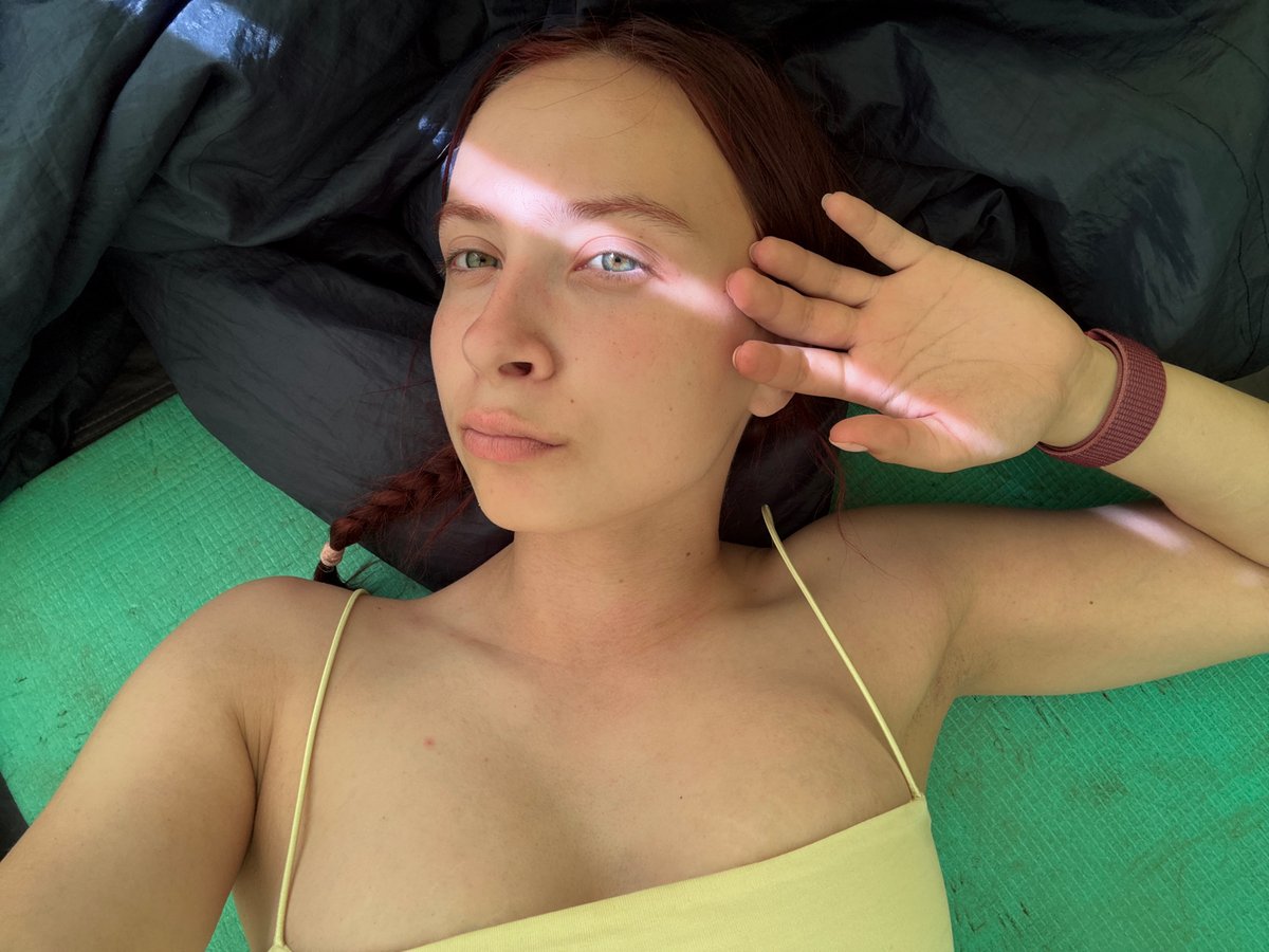 Woman rests in tent while snacking in Khvalynsk