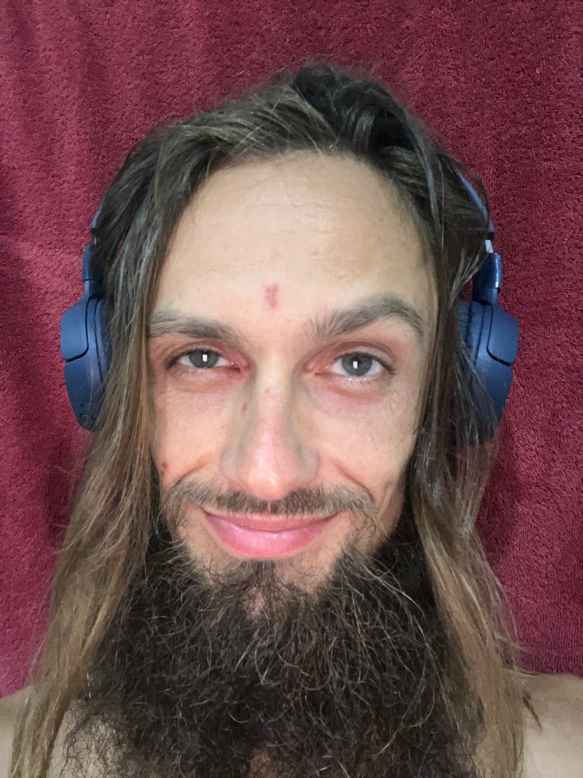 Close-up selfie with blue over-ear headphones
