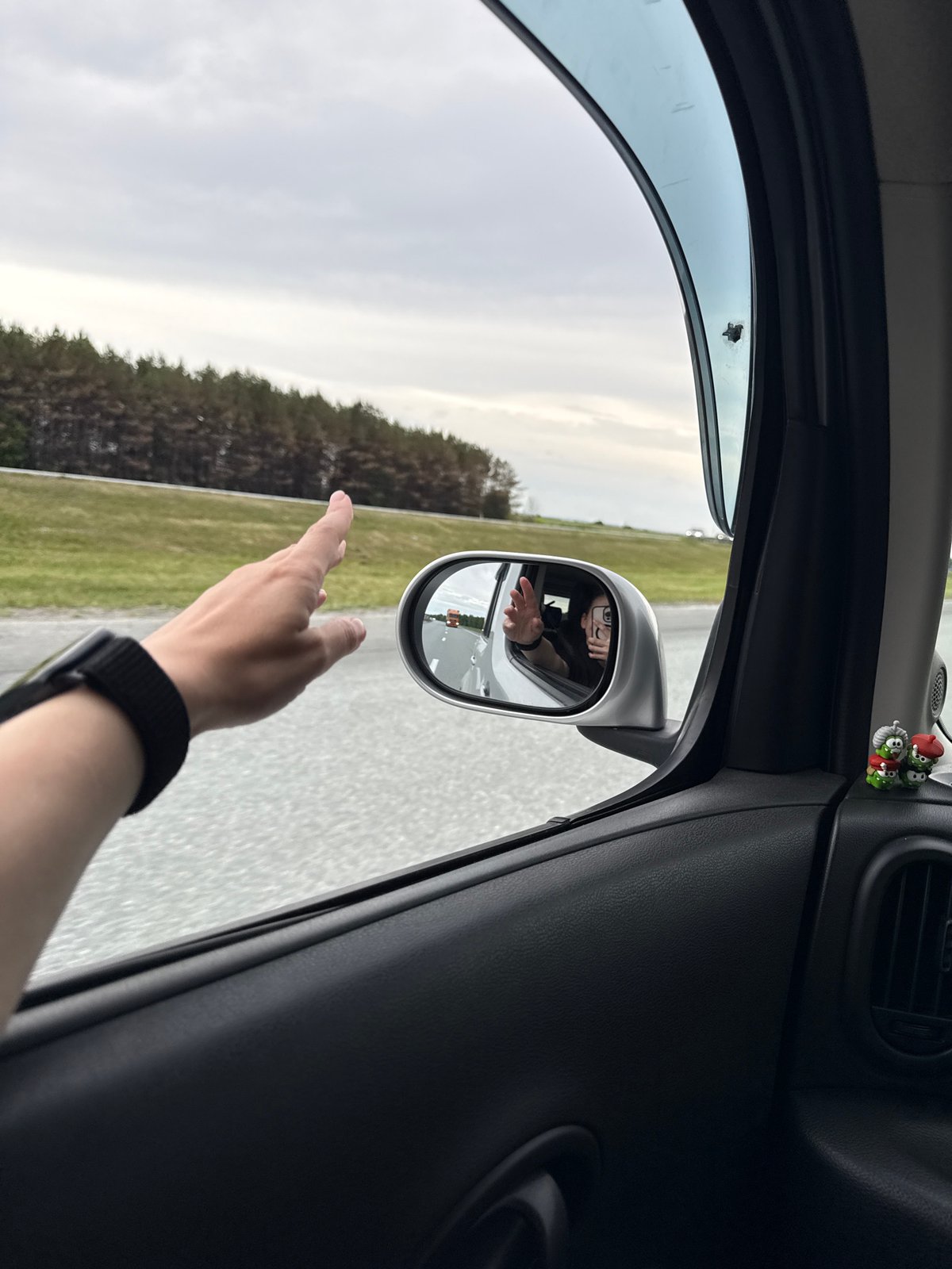 Person waves from car window in Russkie Kirmeni, Russia