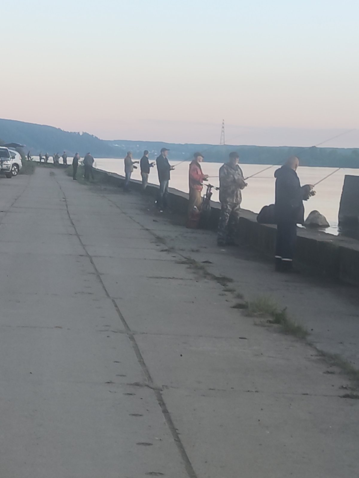 Fishermen gather along waterfront during golden hour sunset