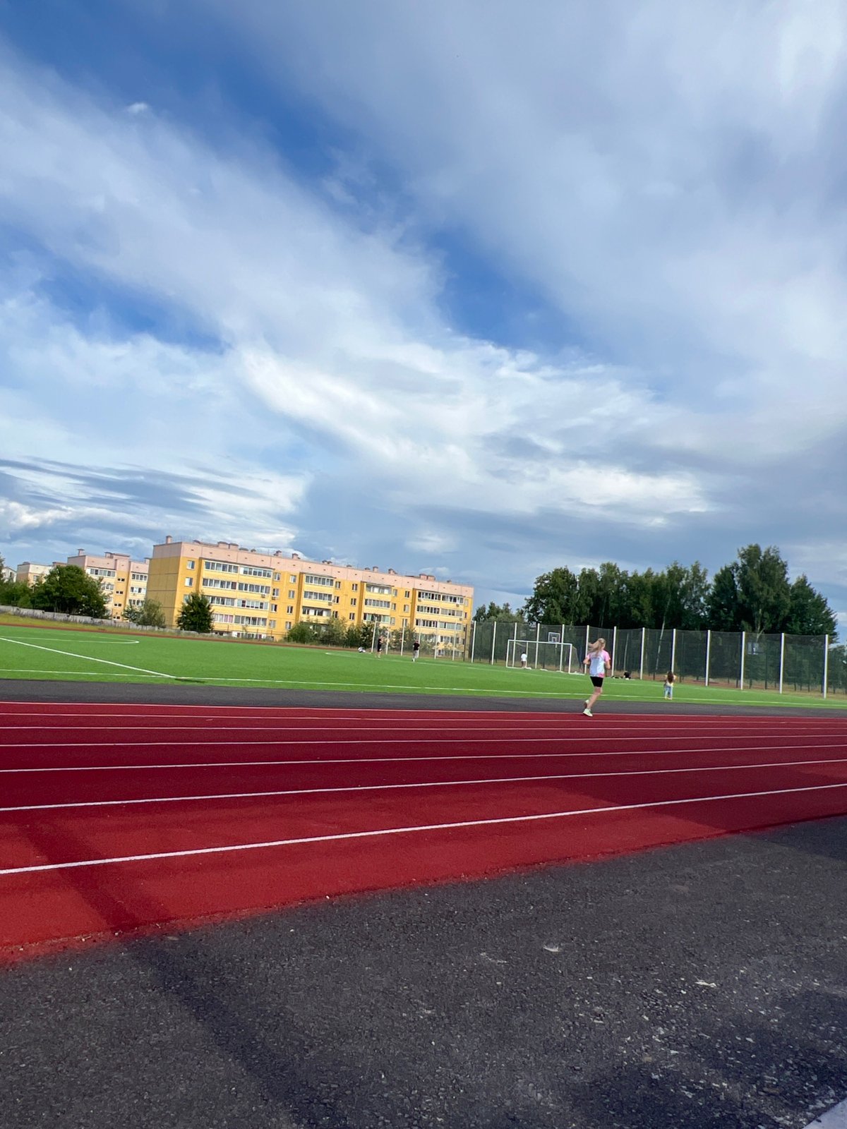 Lazy summer day at a Noviy sports track and nearby homes