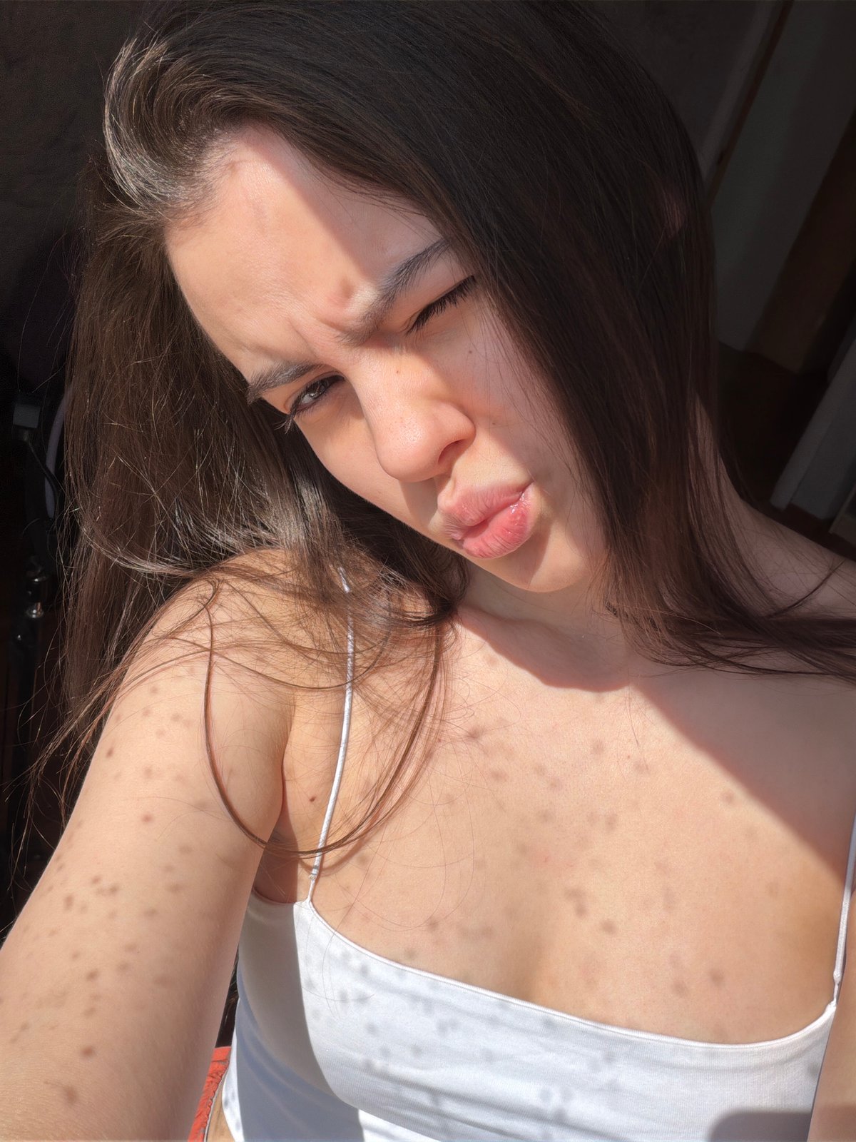 Woman takes selfies in sunlit room in Chaikovsky