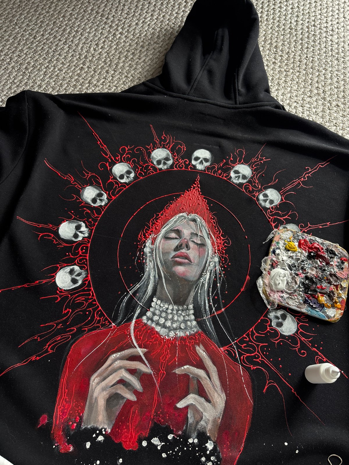 Artist hand-paints decorative designs on black garment in Krasnoyarsk