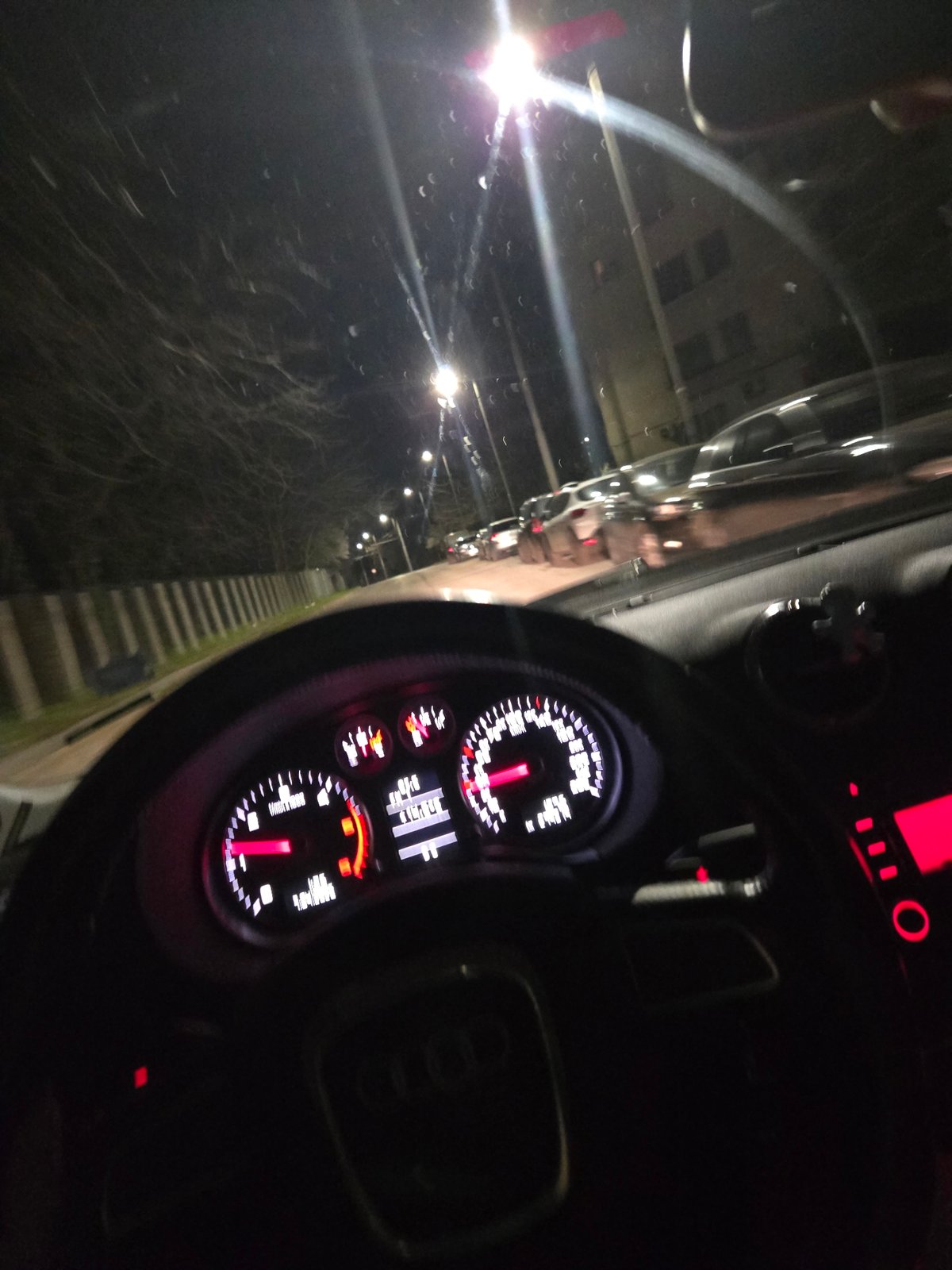 Nighttime Urban Driving Captured Through Audi Dashboard View