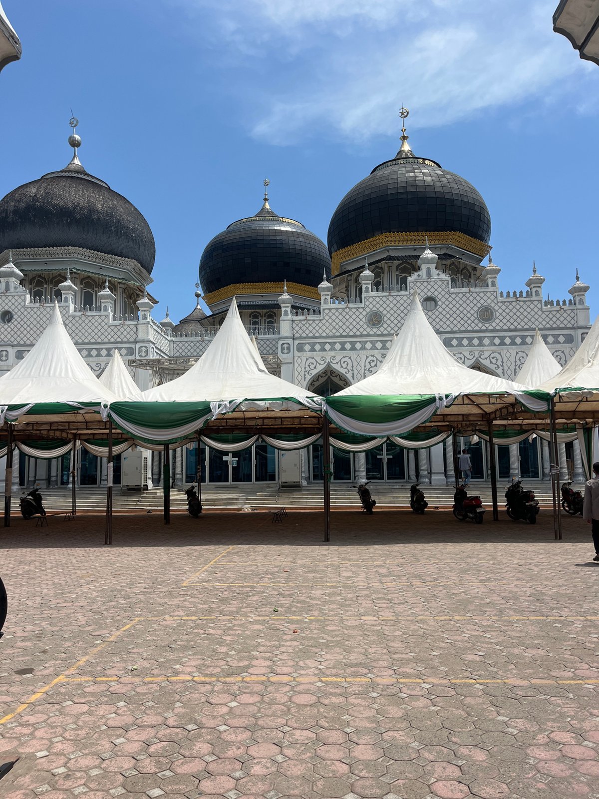 Visitor documents Indonesian mosque architecture and worshippers in morning visit