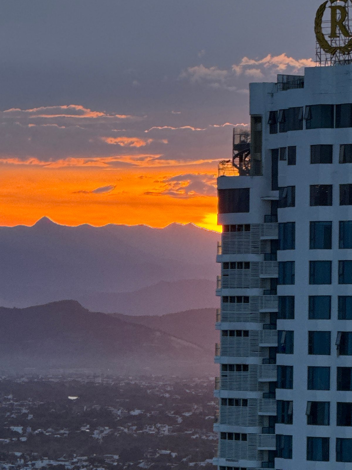Sunset over Nha Trang, high-rises, coastline, and golden skies
