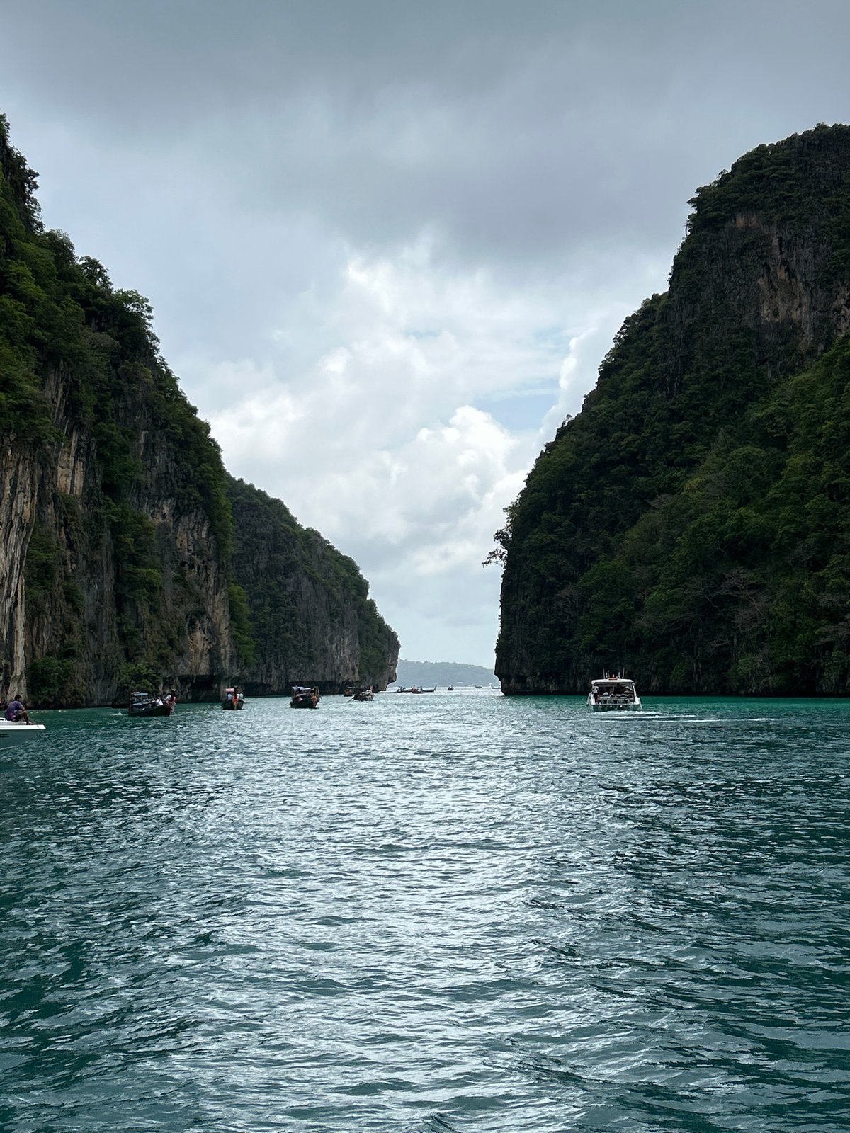 Tourists swim among limestone cliffs in Ao Nang waters