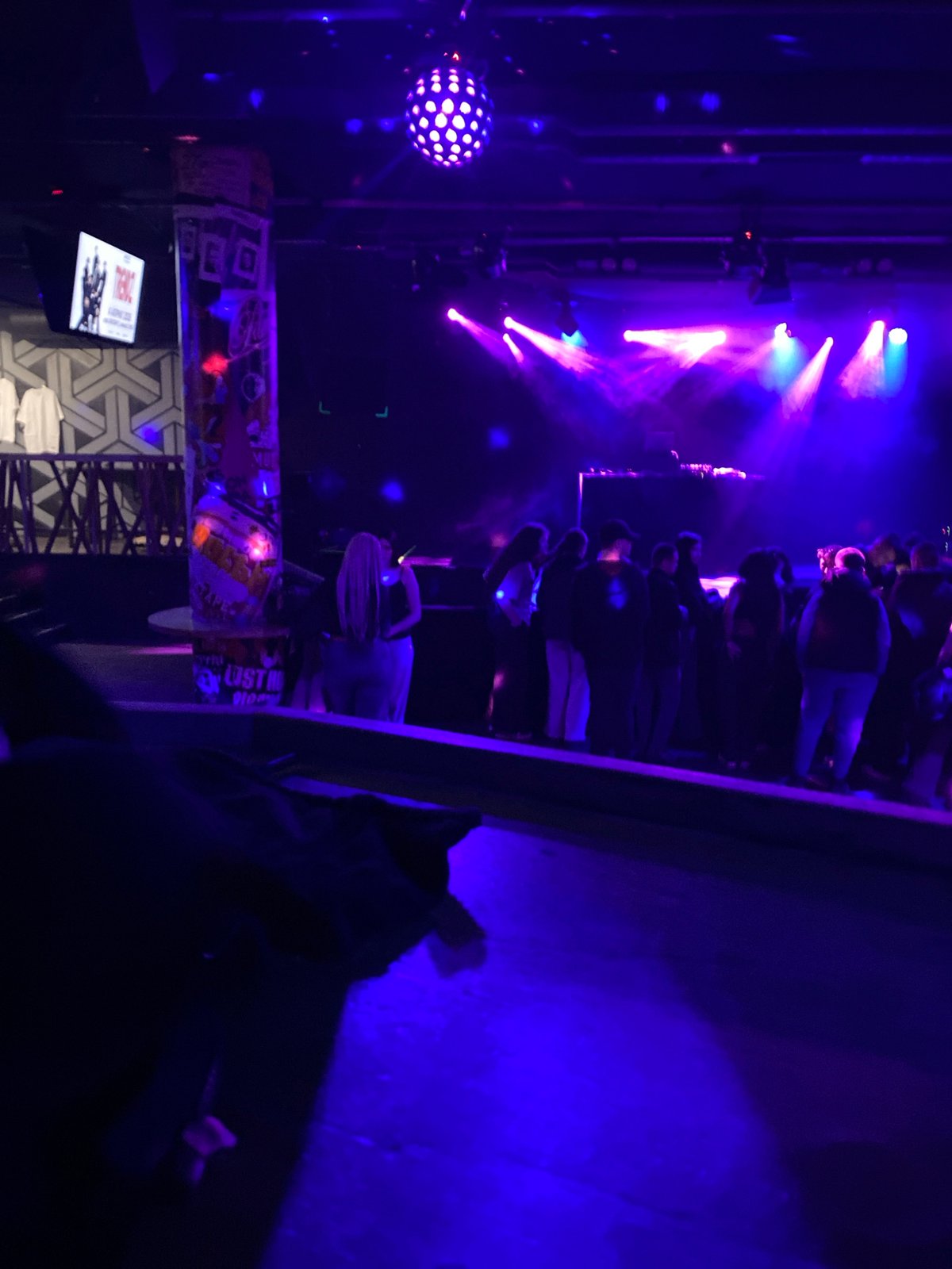 Indoor live performance draws crowd under colorful stage lights