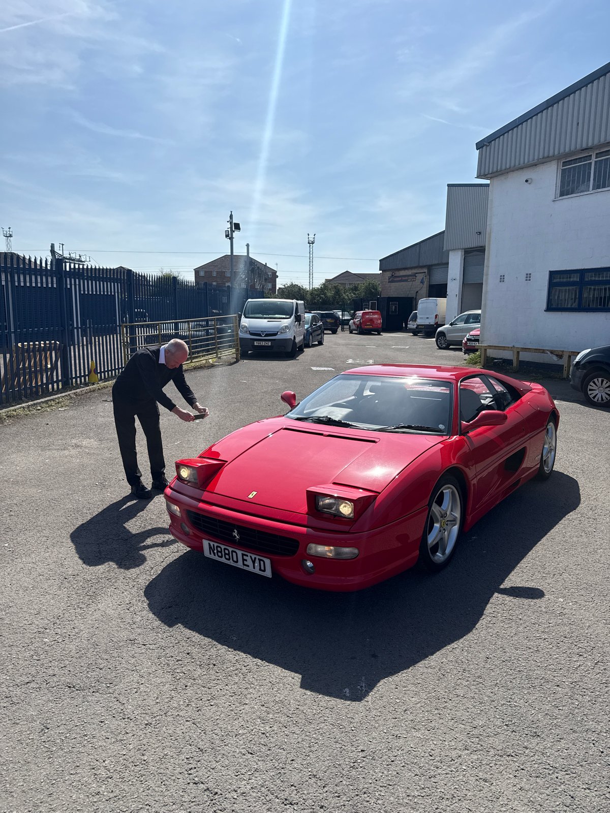 Red Ferrari draws attention at Cardiff industrial site