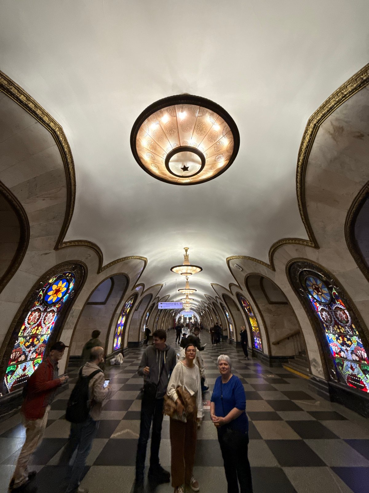 Inside an ornate Soviet-style metro station with mosaic murals