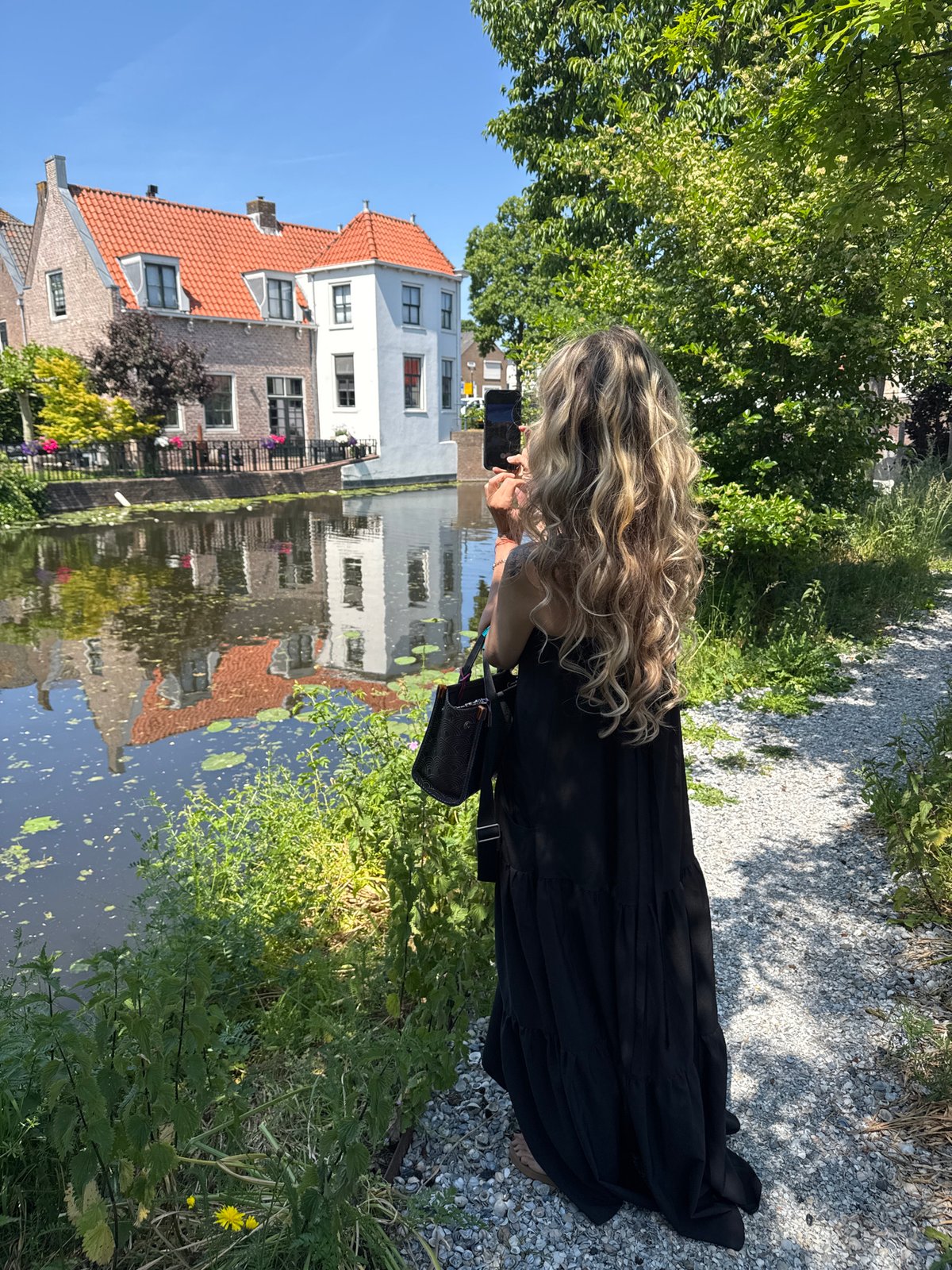 Tourist photographs scenic canals in Dutch coastal town