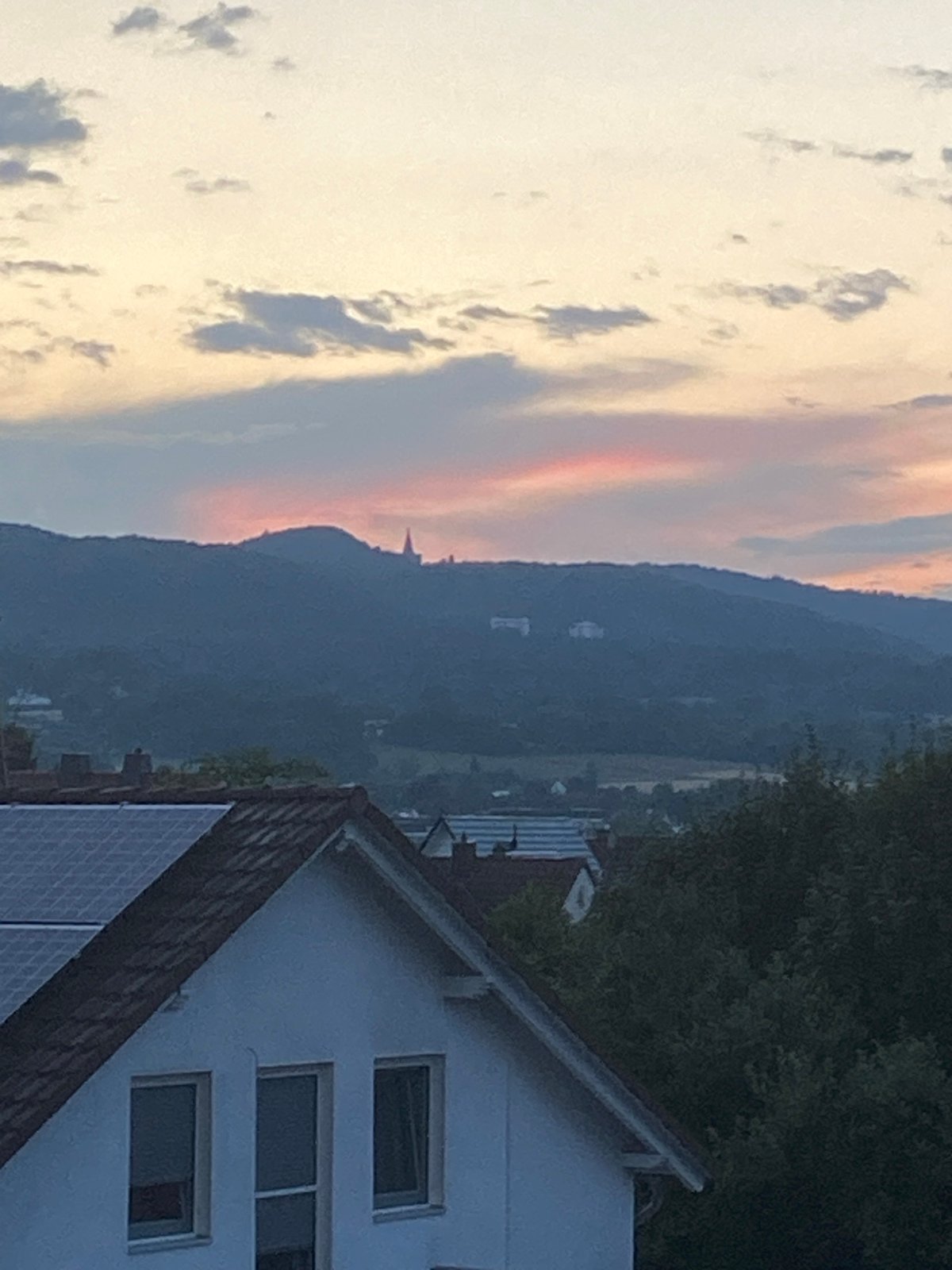 Kassel rooftop and hills at twilight, solar panels in view