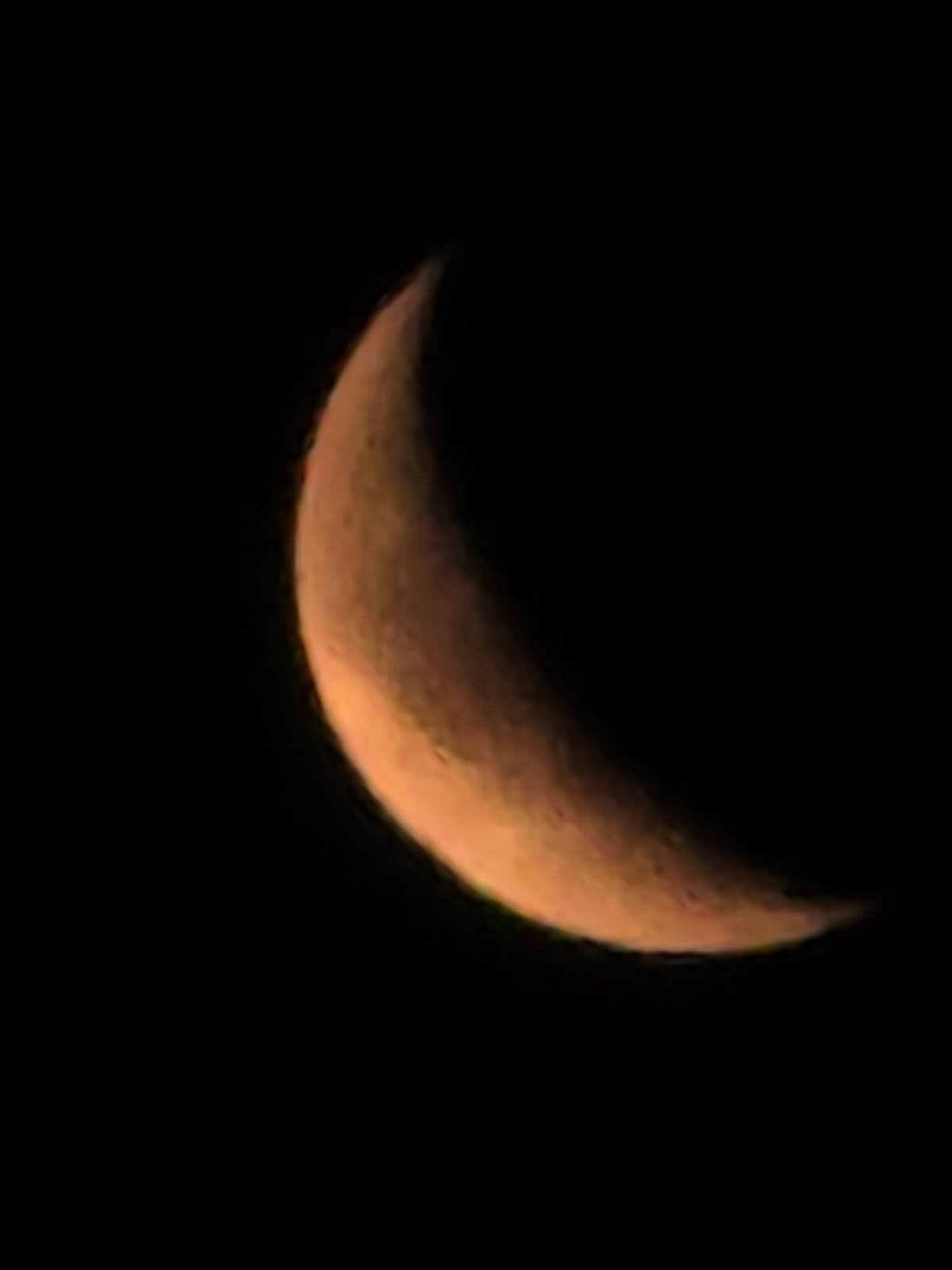 Crescent moon reflects across dark water on a quiet night
