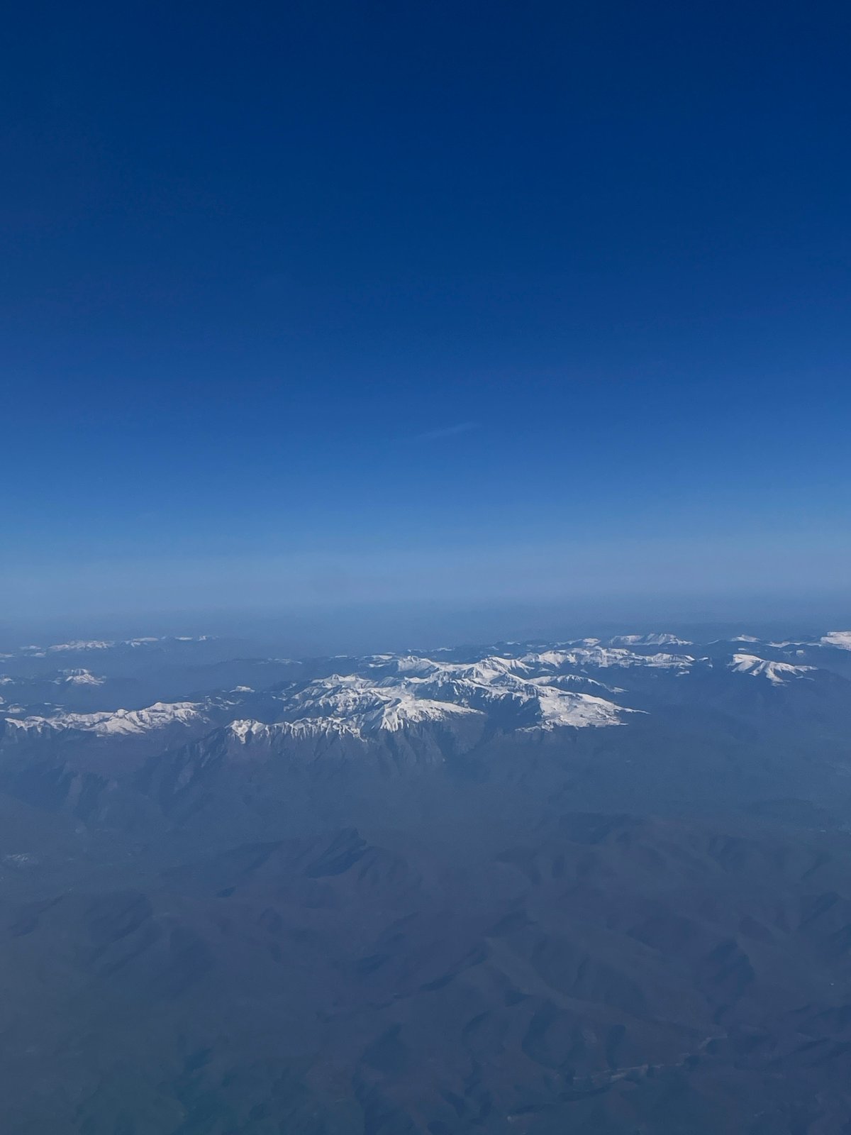 Aerial view captures snow-covered Albanian mountains from airplane