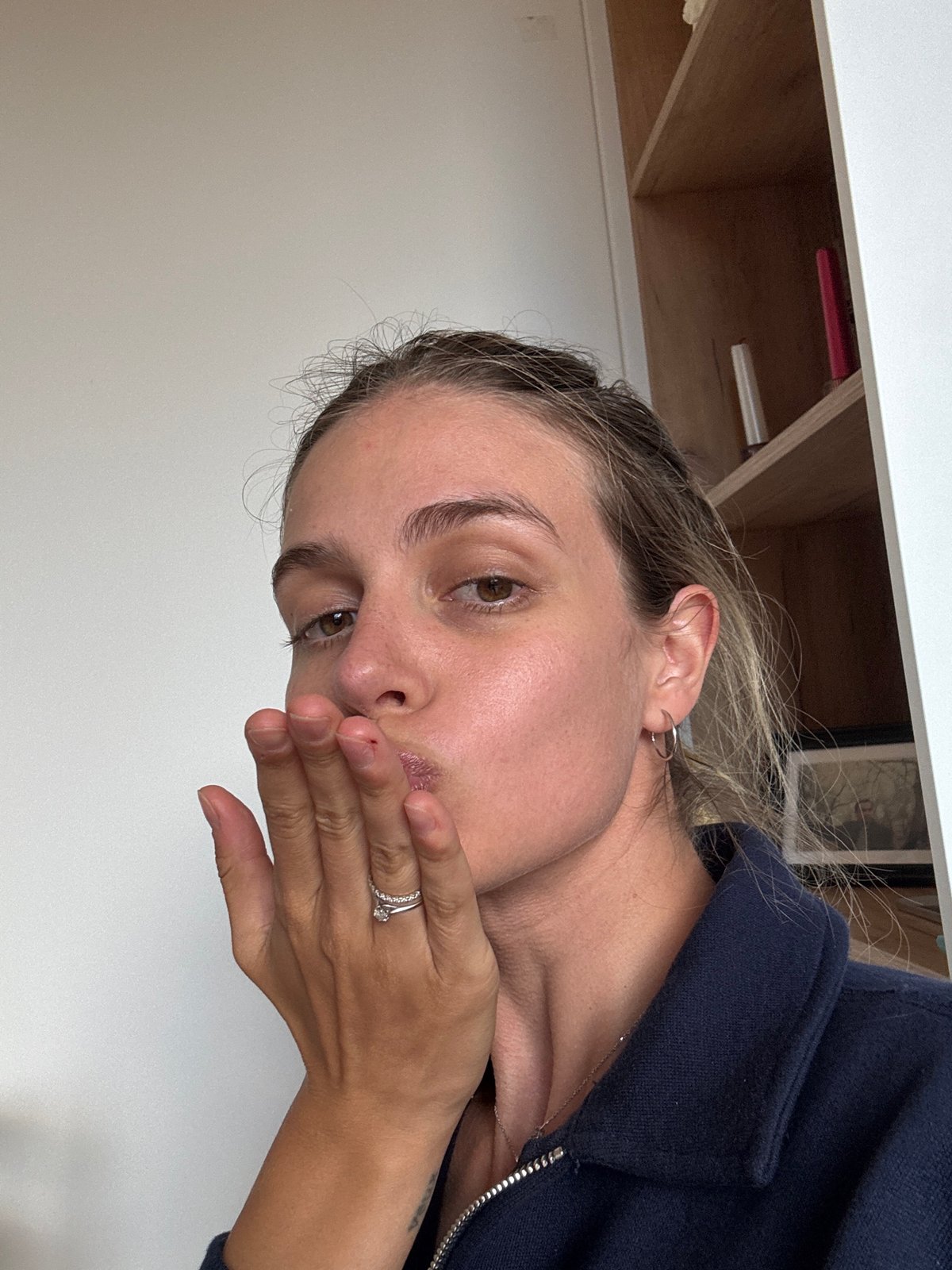 Woman covers mouth in indoor photograph