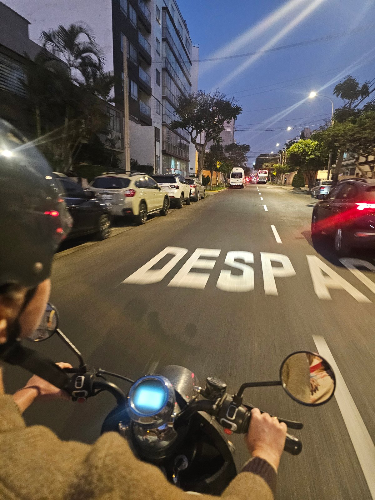 Motorcycle rider travels through Miraflores streets at night